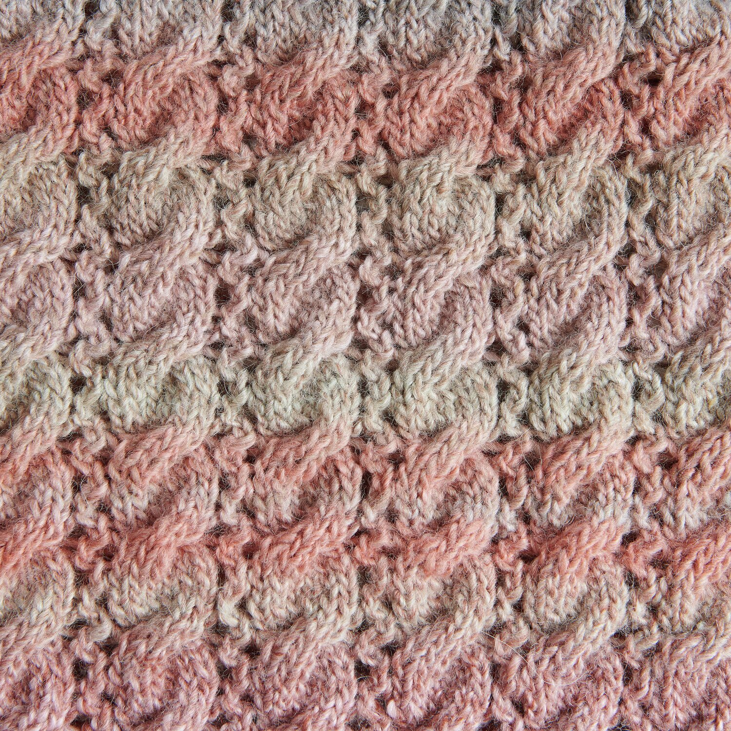Creative Melange Alpaca Wonderball dk zeigt ein gestricktes Zopfmuster in sanften Rosa- und Beigetönen. Ideal für Herbstprojekte.