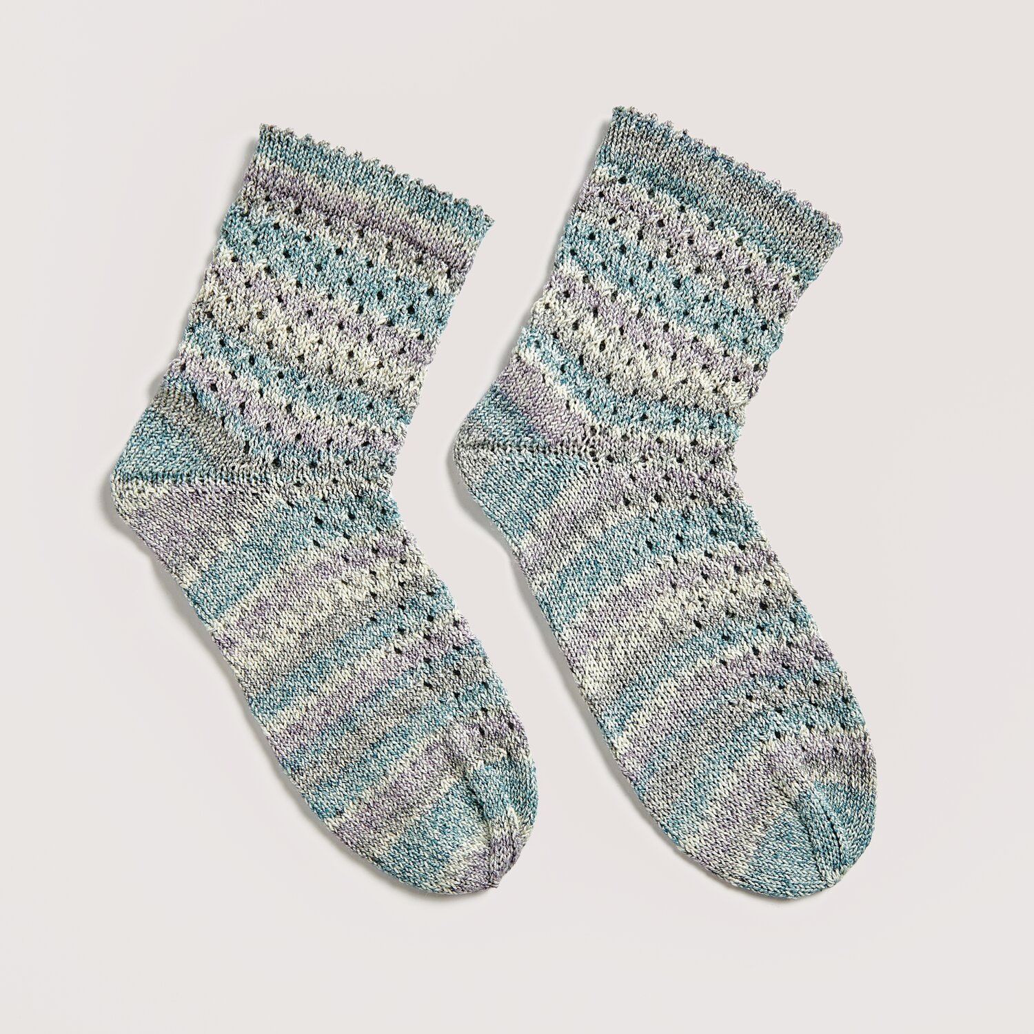 Die Neue Masche No. 12 Frühjahr-Sommer von idee. Creativmarkt Strickset Socken Modell 14a aus Die Neue Masche No. 12, gestrickt in Aqua-Tönen, zeigt ein feines Lochmuster. Ideal für Frühling und Sommer.