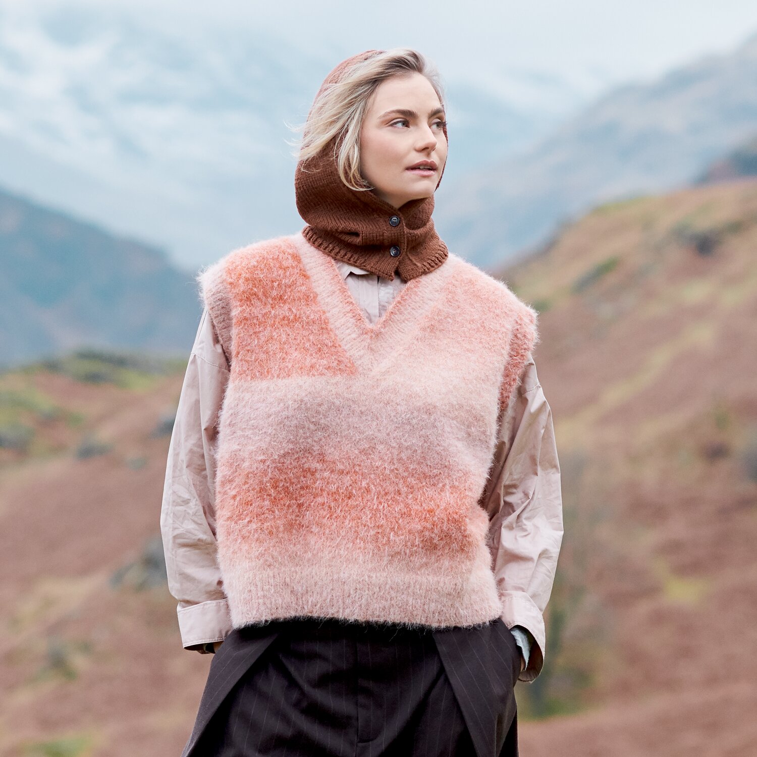 Strickset Pullunder Modell 33 aus Lovewool No. 23, flauschiger ärmelloser V-Ausschnitt-Pulli in sanften Rosé-Tönen, getragen von Frau in Berglandschaft