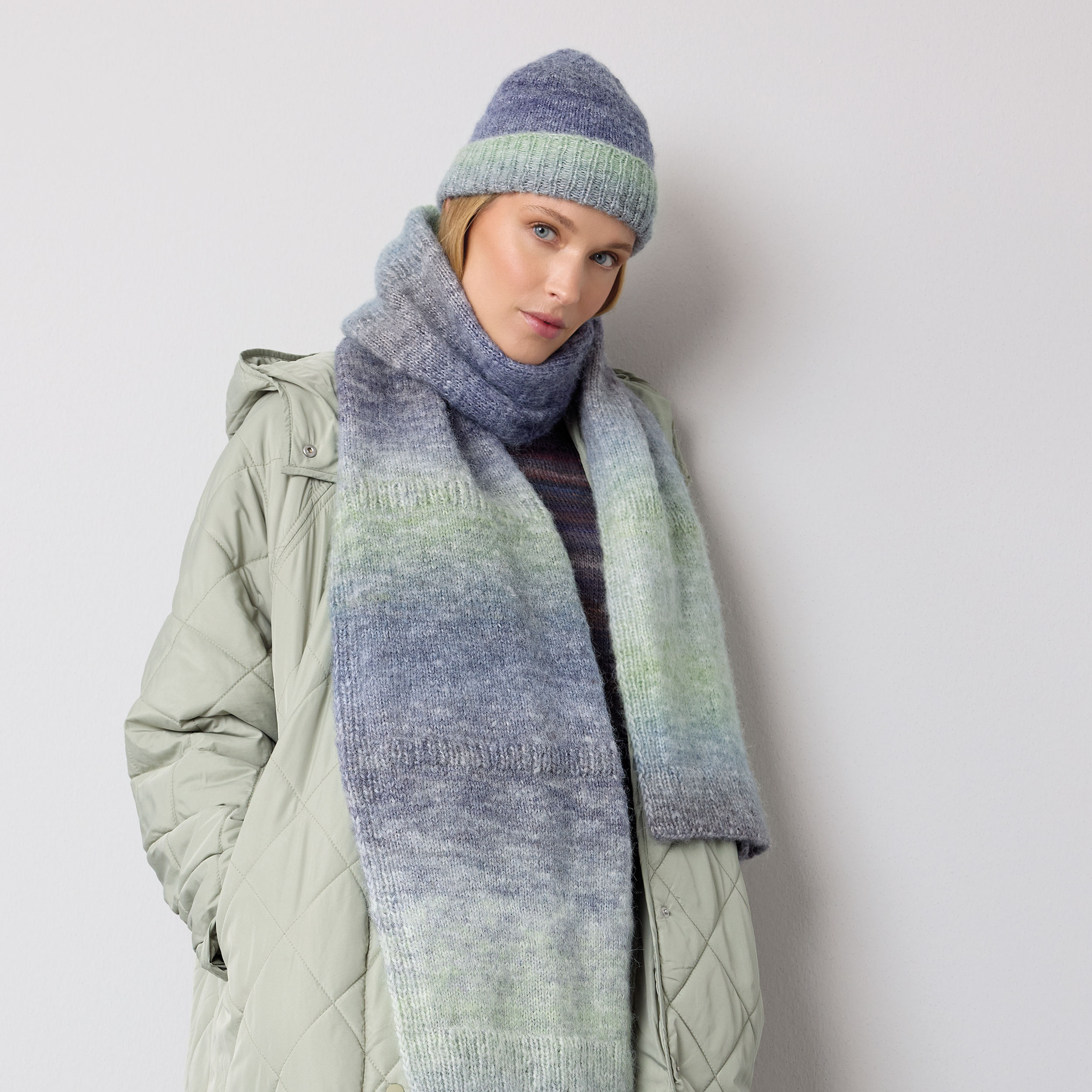 Frau trägt gestrickten Schal und gestrickte Mütze