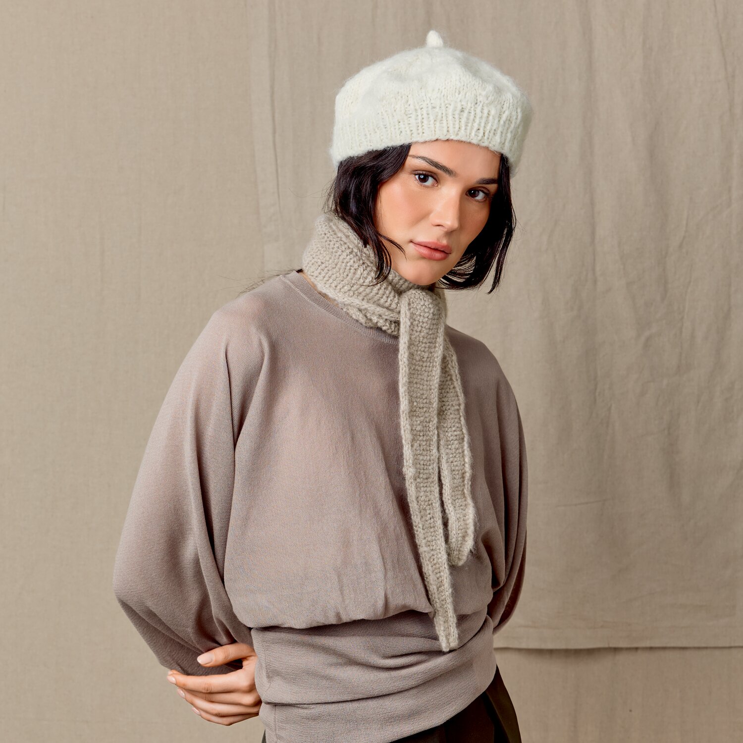 Strickset Barret Modell 18 aus Luxury Knits Little Pieces, weiche Baskenmütze mit passendem Strickschal in Naturtönen, getragen von Frau vor neutralem Hintergrund