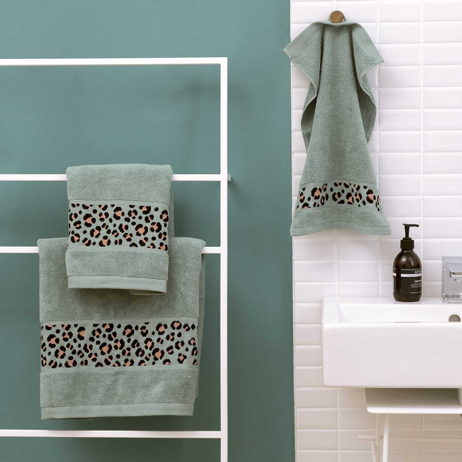 Gästehandtuch 30x50cm in Meergrün von Rico Design mit Leopardenmuster, aufgehängt im Badezimmer.