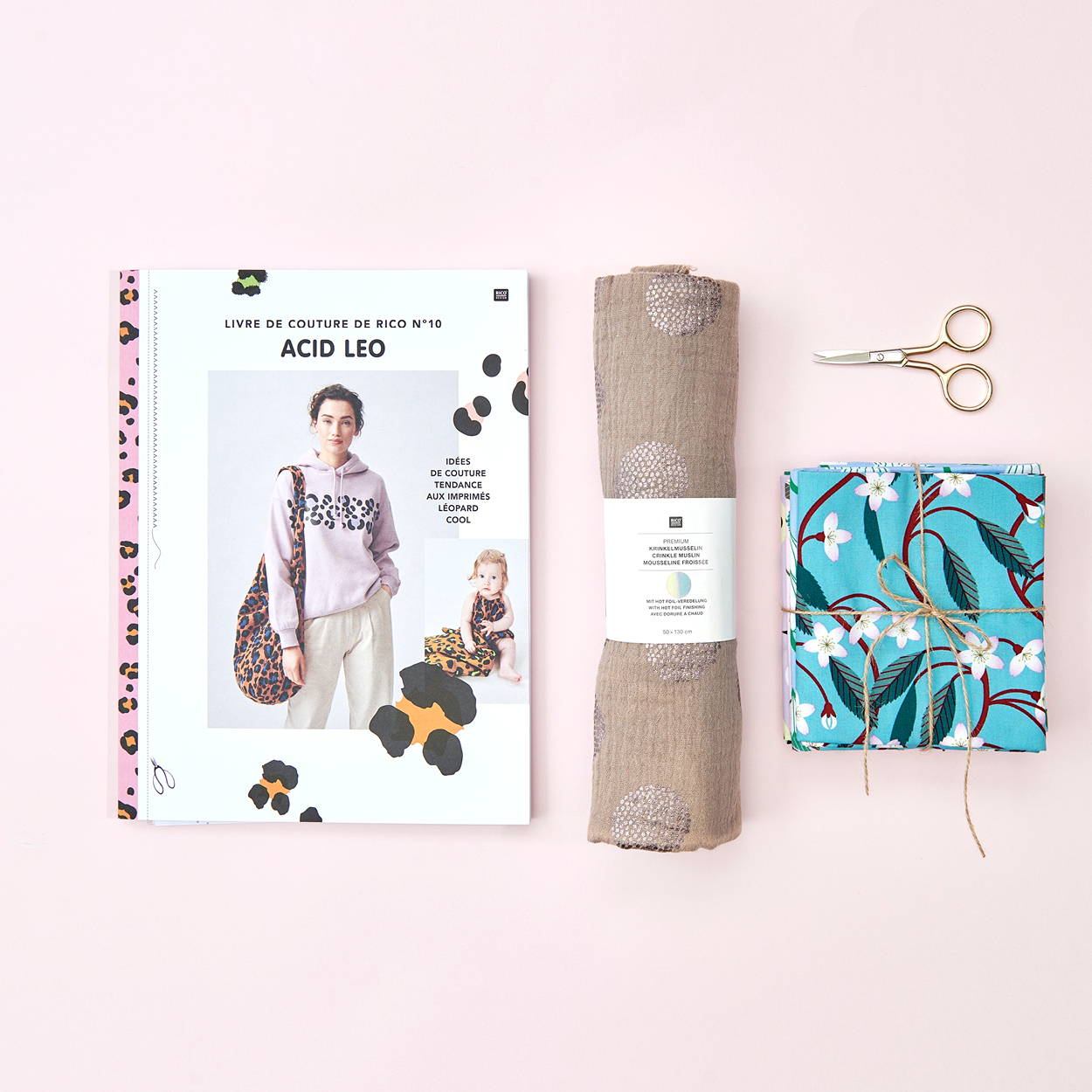 Das kleine Rico Nähbuch No. 10 Acid Leo mit verschiedenen Stoffen und einer Schere. Flatlay von Produkten.