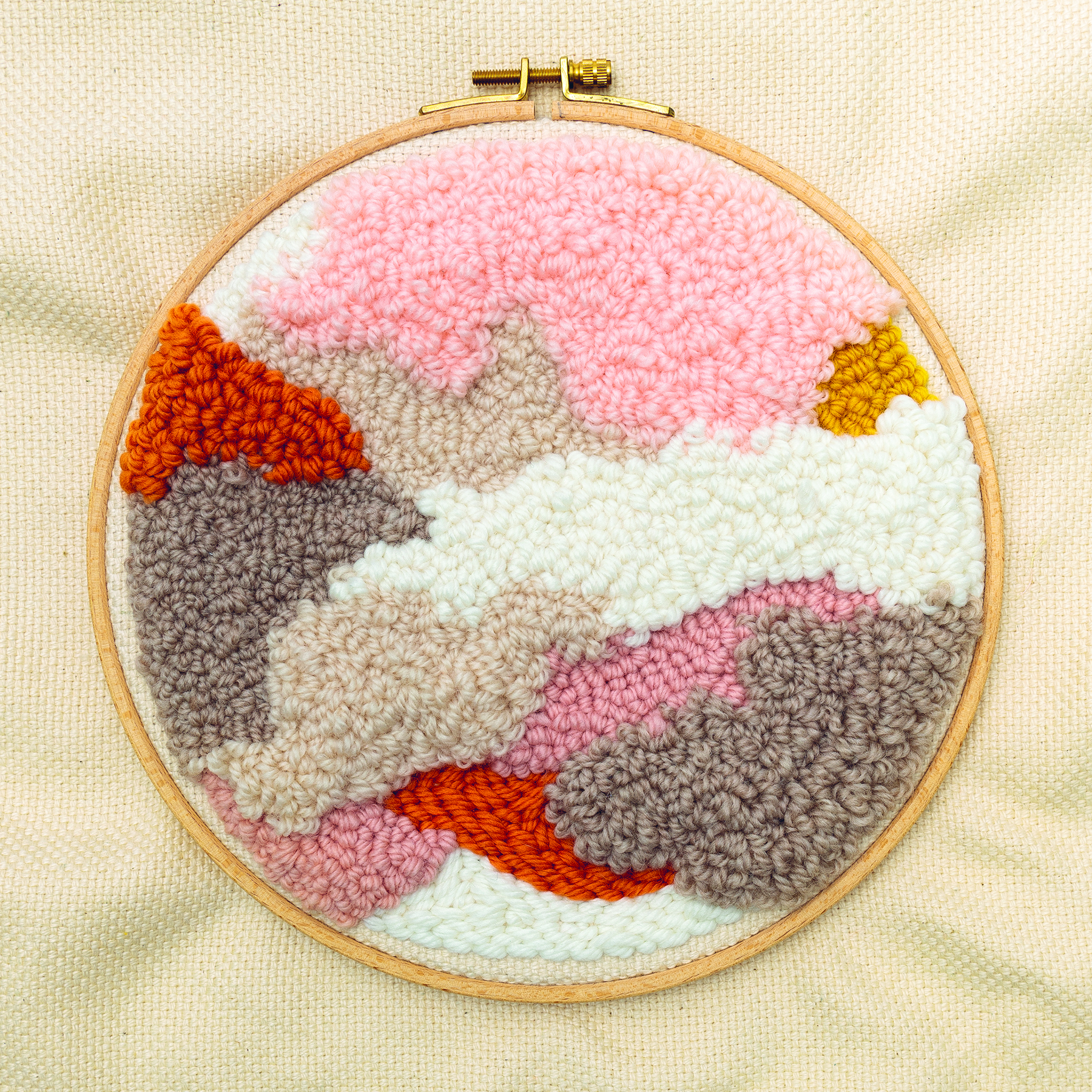 Punch Needle Motiv mit abstrakter Landschaft ist in Stickrahmen gespannt