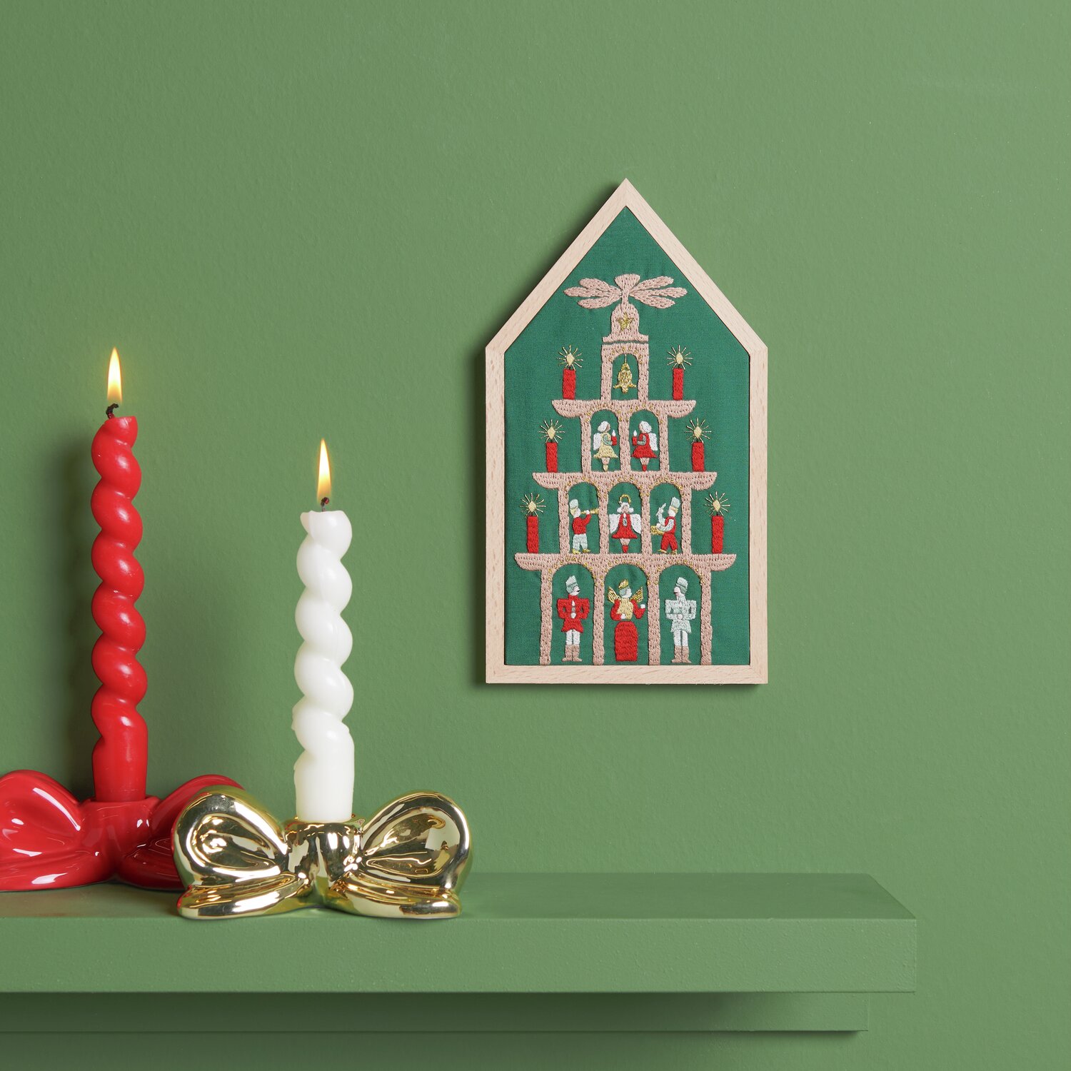 Stickpackung Pyramide vorgezeichnet 12,5x22,5cm von Rico Design Stickpackung Pyramide vorgezeichnet von Rico Design, zeigt eine festliche Szene mit Kerzen auf grünem Hintergrund.