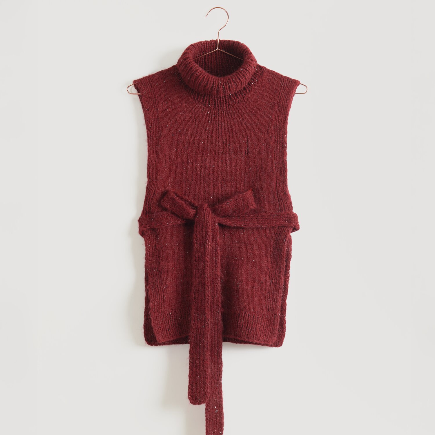Ärmelloser, roter Strickpullover mit Rollkragen und Bindegürtel, aufgehängt an einem Kleiderbügel. Marke: Modell Legeware. Perfekt für stilvolle, gemütliche Outfits.