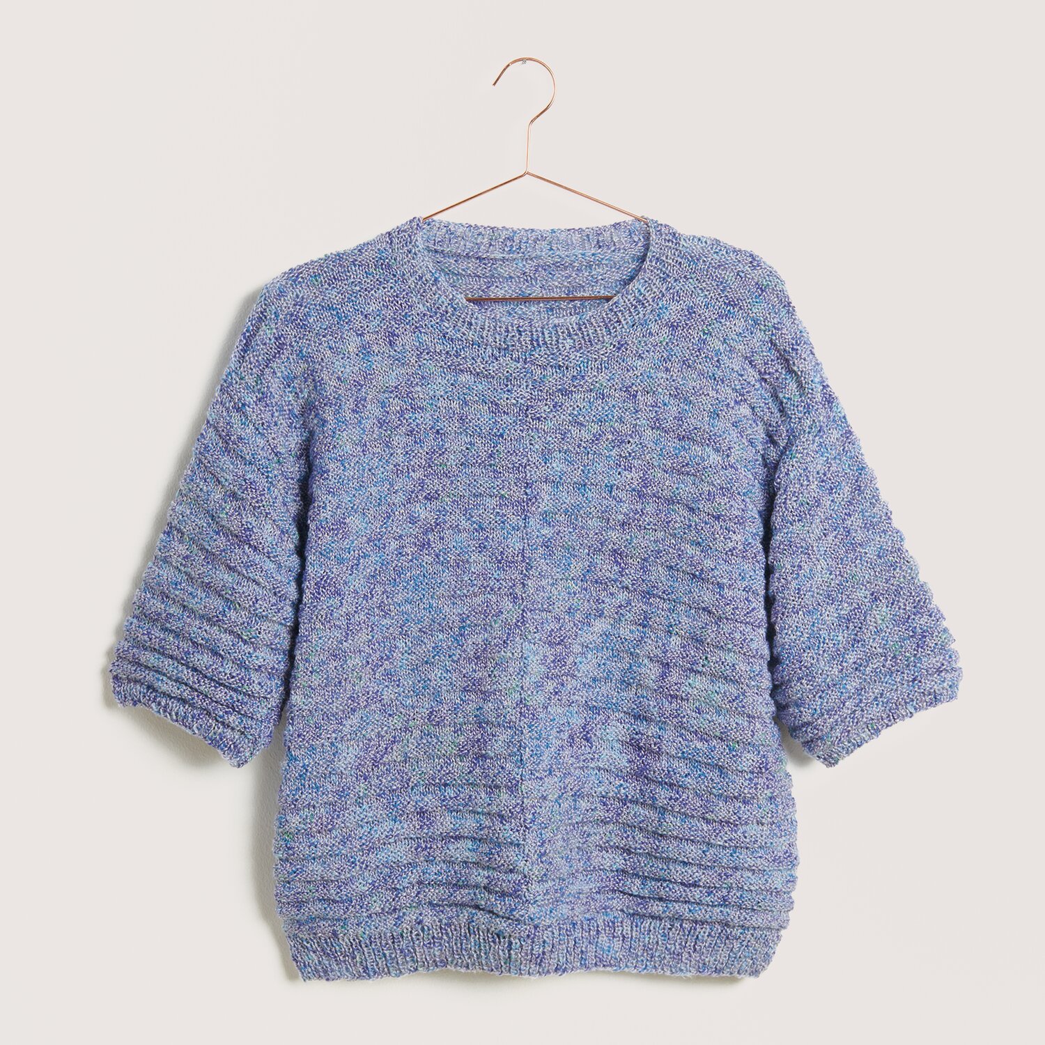 Strickset Shirt Modell 25, blau-lila meliert, aus Die Neue Masche Nr. 9, auf einem Kleiderbügel.