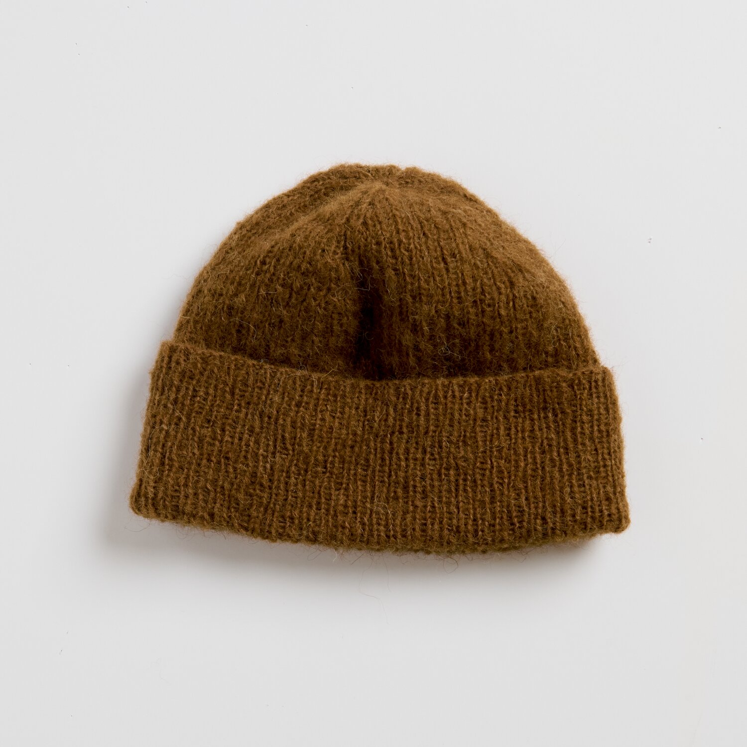 Strickset Mütze Modell 10 aus Luxury Knits Little Pieces, weiche beanieartige Wintermütze mit breitem Umschlagrand in warmem Braunton auf neutralem Hintergrund