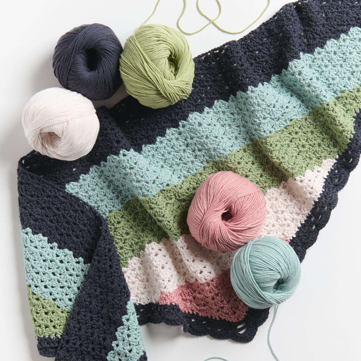 Creative Sport dk: Bunte Häkeldecke mit Wolle in Marine, Moos, Lachs und Aqua, ideal für Frühjahr-Sommer.