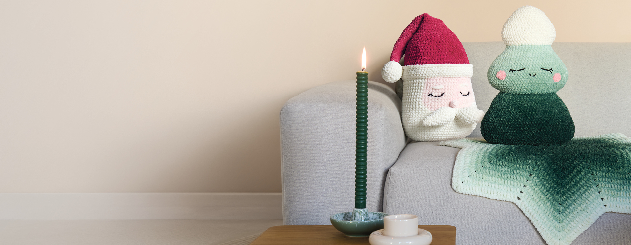 Gehäkelter Weihnachtsmann und gehäkelter Tannenbaum auf Sofa