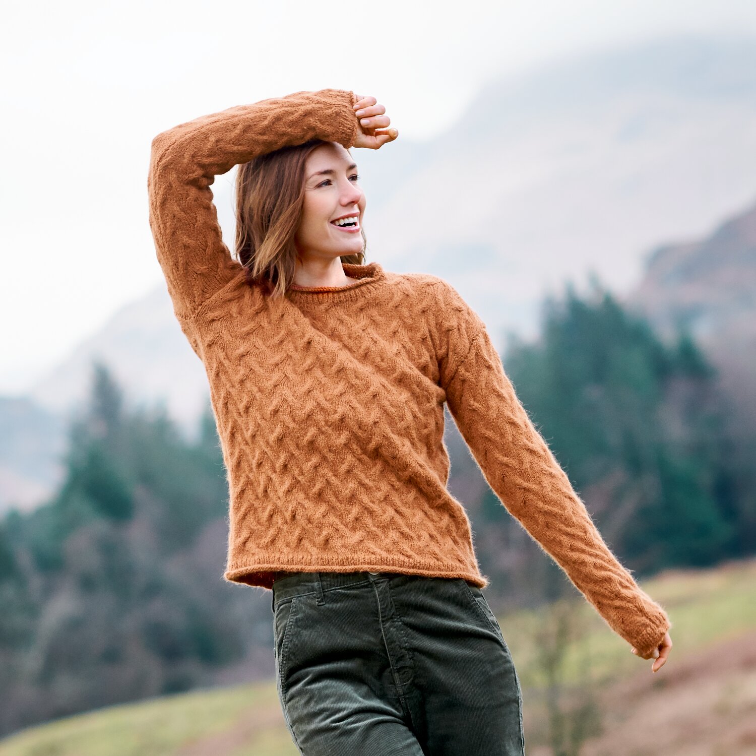 Strickset Pullover Modell 36 aus Lovewool No. 23, strukturierter Damenpullover in warmem Rostton, getragen von junger Frau in herbstlicher Berglandschaft