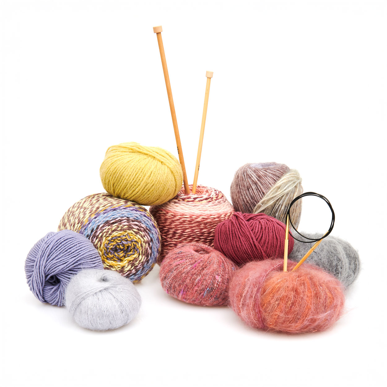 Verschiedene Garne in unterschiedlichen bunten Farben mit Stricknadeln