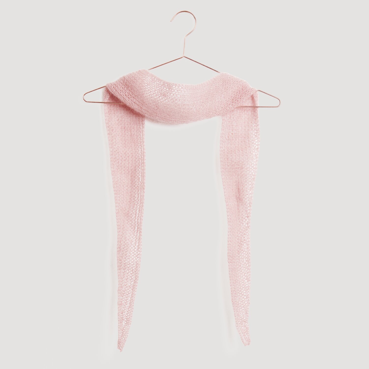 Ein zartrosa Schal aus weichem Strickstoff hängt auf einem Kleiderbügel. Der Schal gehört zur Kollektion "Modell Legeware". Ideal für stilvolle Akzente in der Garderobe.