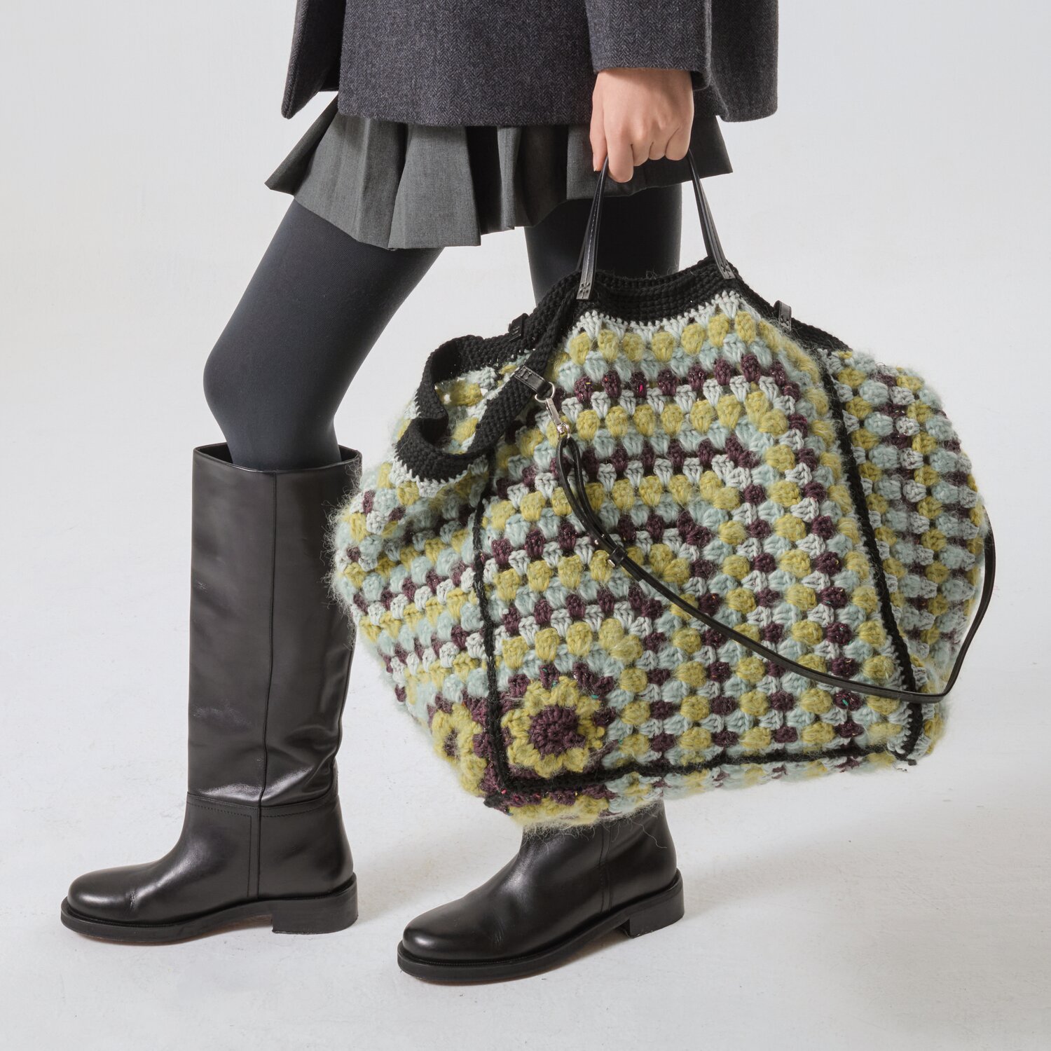 Häkelset Tasche Modell 22 aus MBM No. 21, bunte Häkelmuster, getragen von Person in schwarzem Outfit.