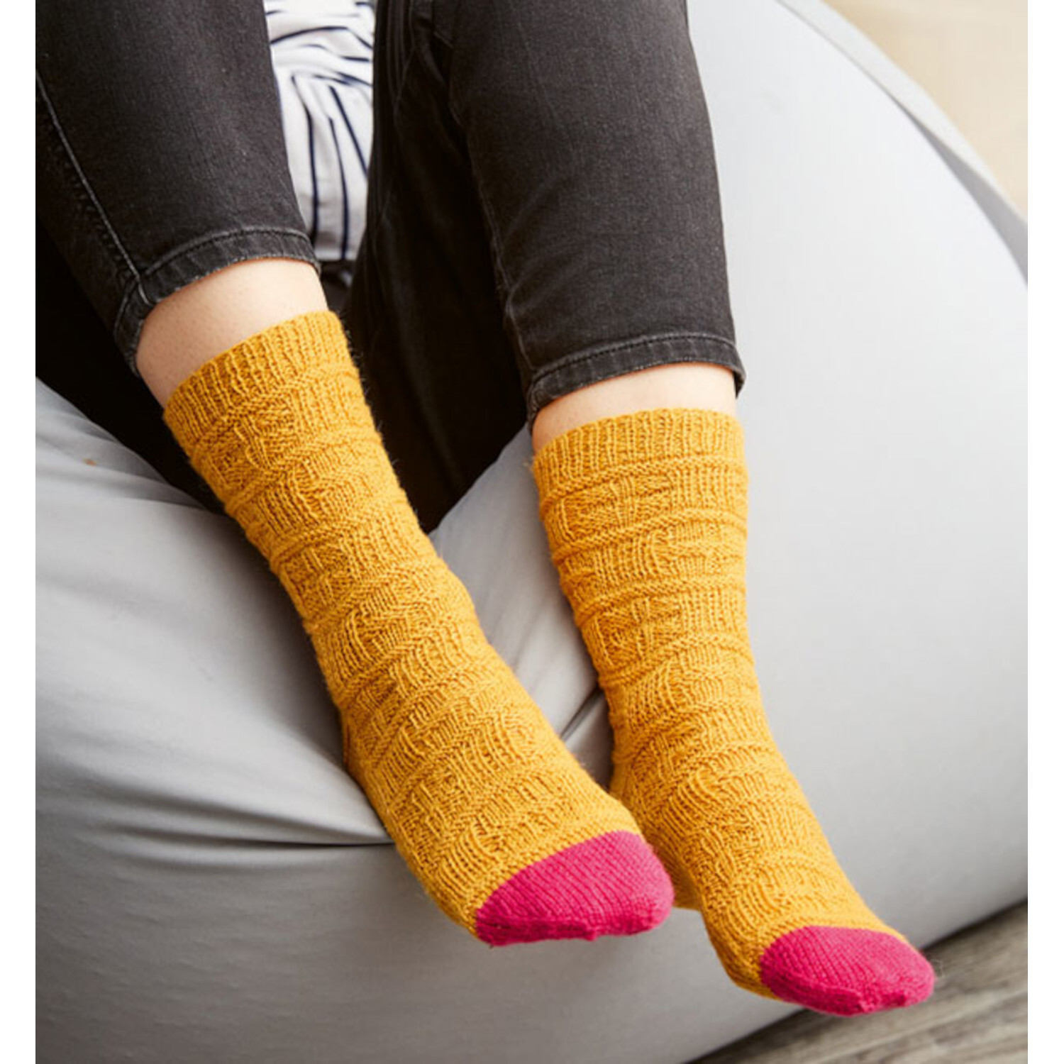 Oh du sockige Weihnachtszeit - Adventskalender: Gelbe Socken mit pinken Spitzen auf grauem Sitzsack.