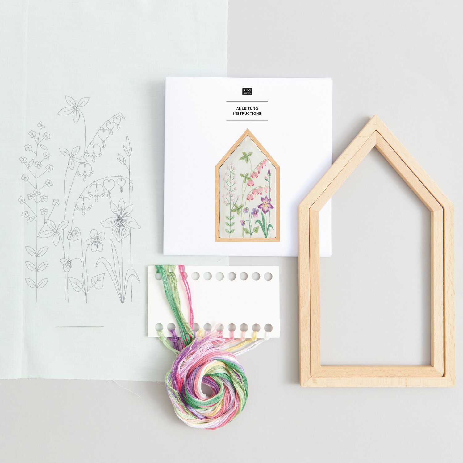 Stickpackung Vorgezeichnet Frühlingshafte Blumenwiese mit Holzrahmen, Garn und Anleitung von Rico Design, ideal für kreative Projekte.