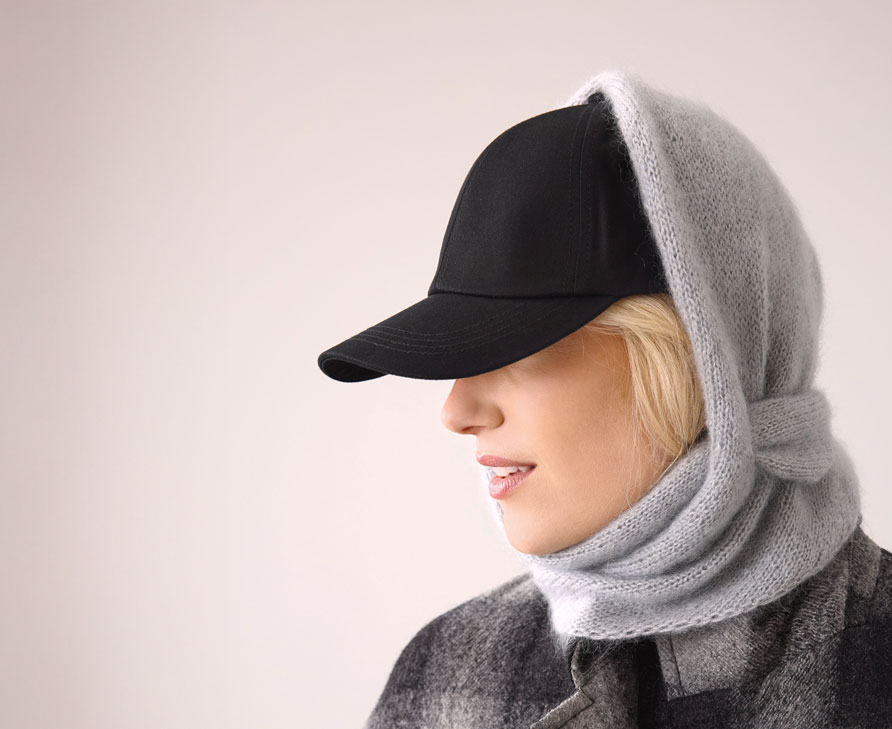 Frau trägt graues Stricktuch über schwarzer Kappe