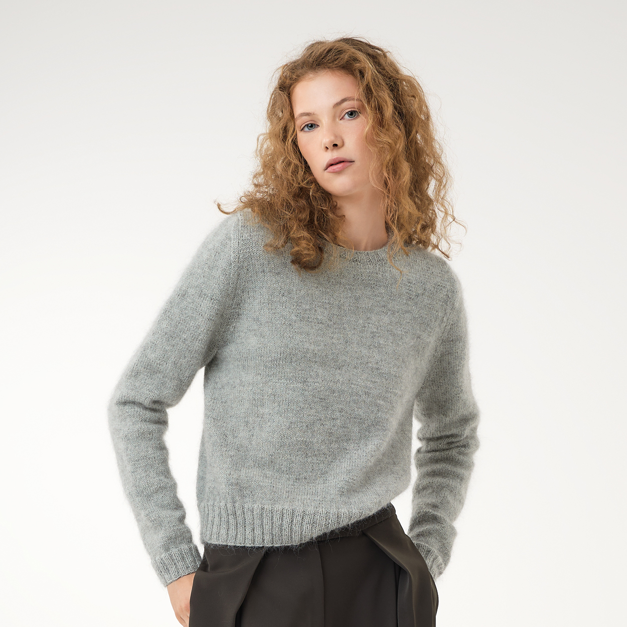 Frau trägt grauen Strickpullover