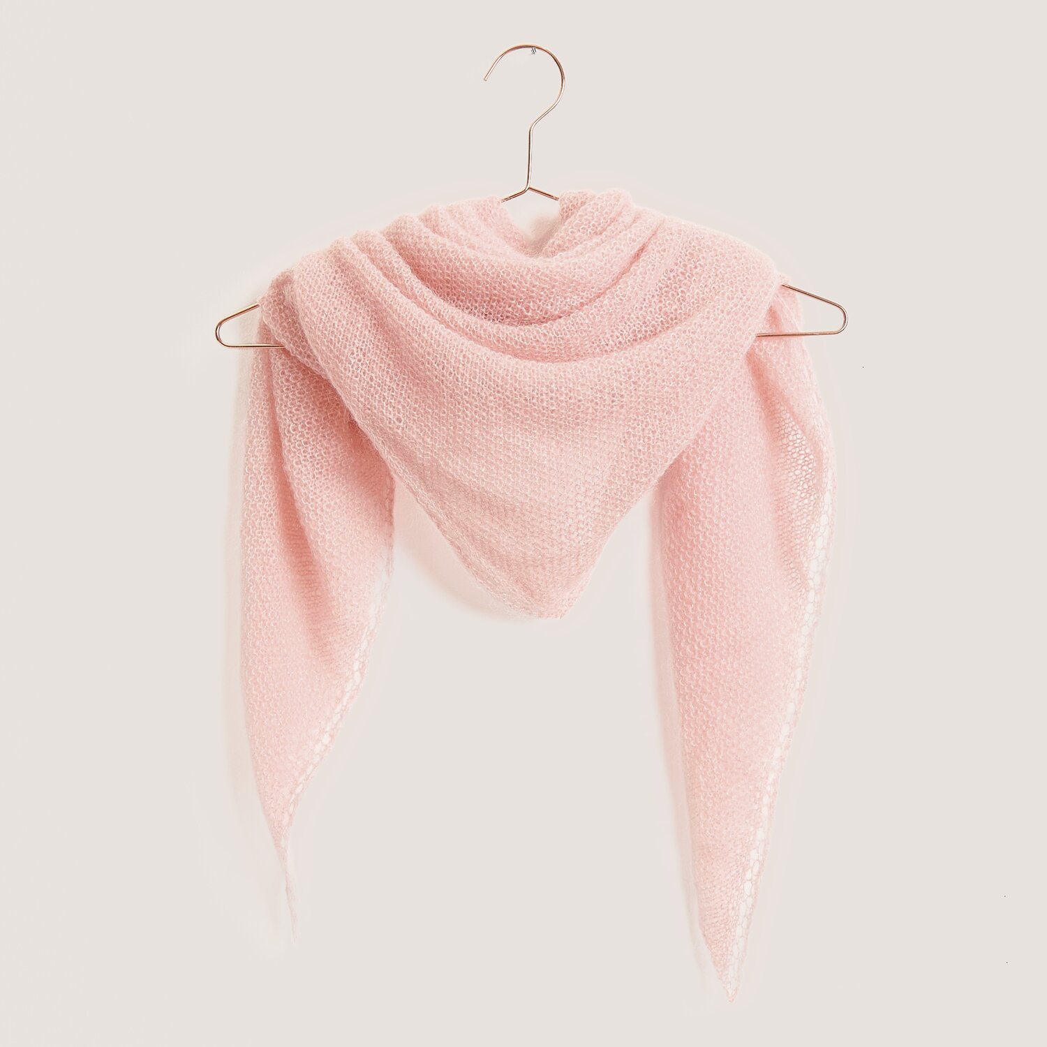 Strickset Dreieckstuch Modell 07 in Apricot, aus Mohair-Seide-Mischung, auf einem Bügel präsentiert.