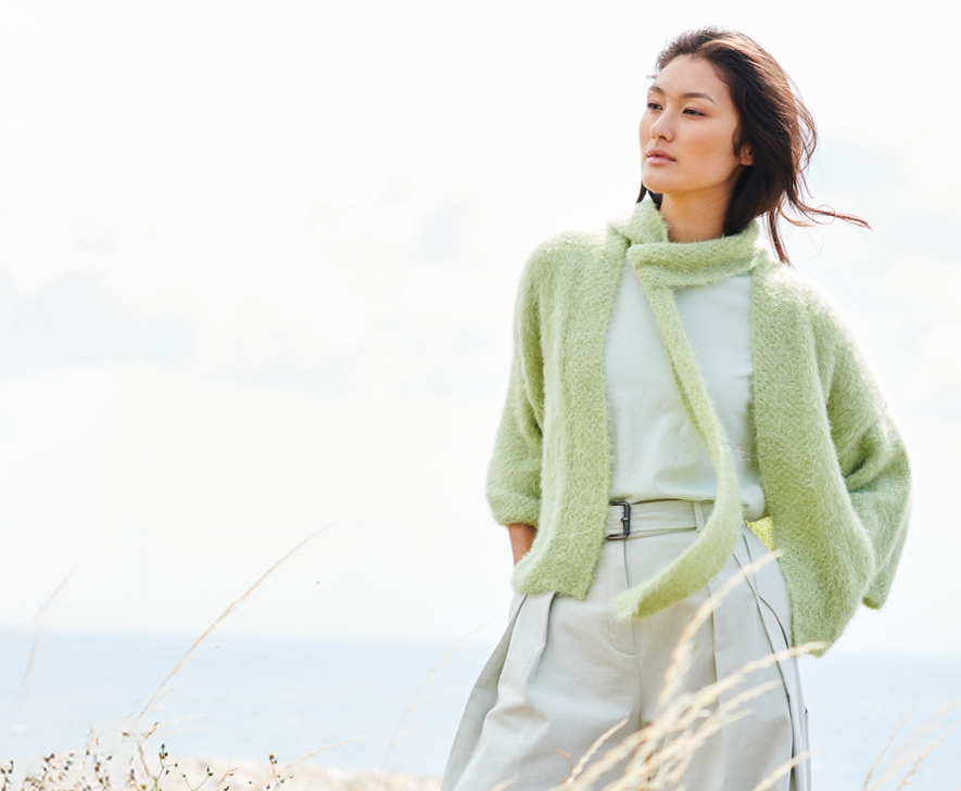 Frau mit grüner Strickjacke und Schal