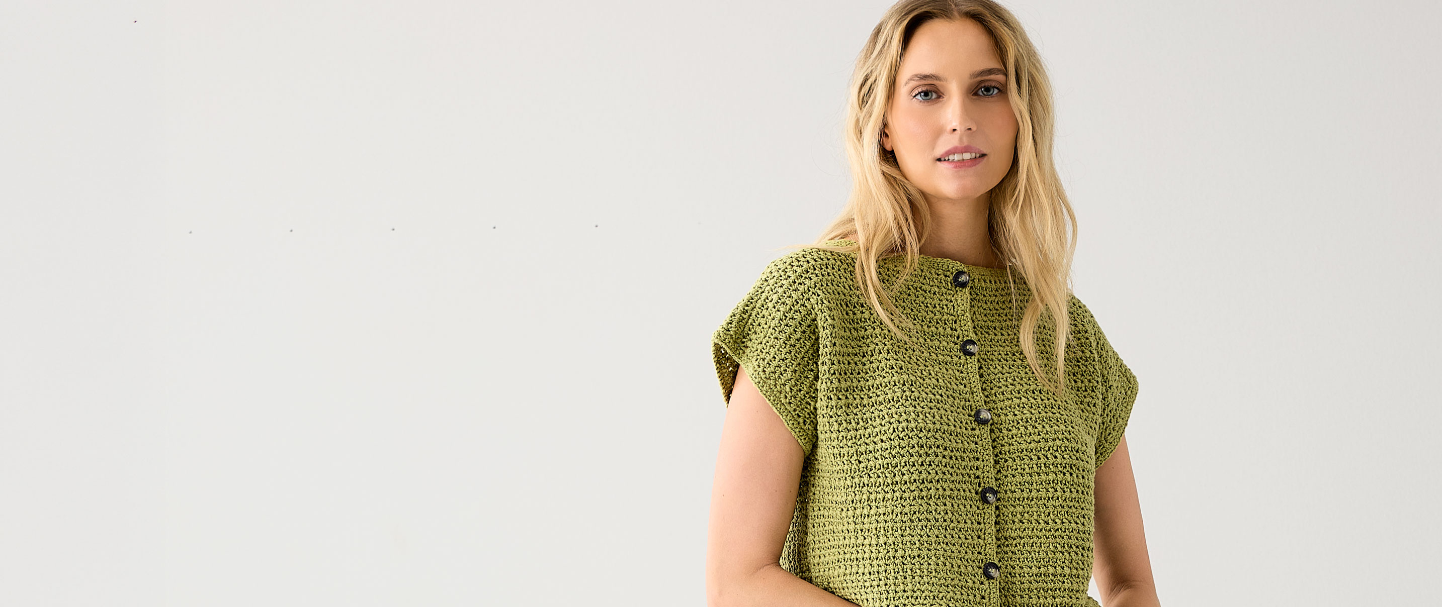 Frau trägt grüne Häkelweste