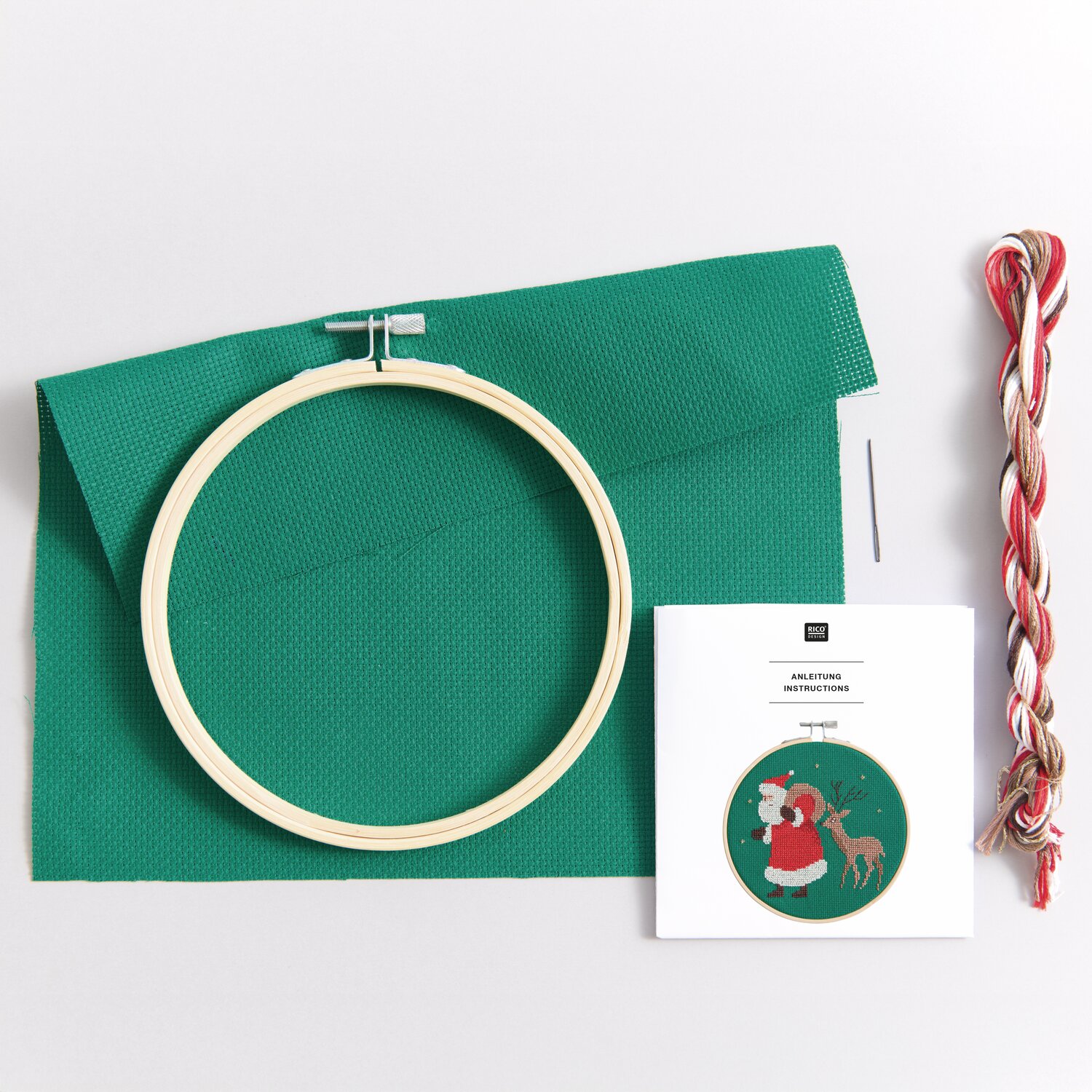Stickpackung Santa und Reh: Grüner Stoff, Stickrahmen, Garn und Anleitung von Rico Design.