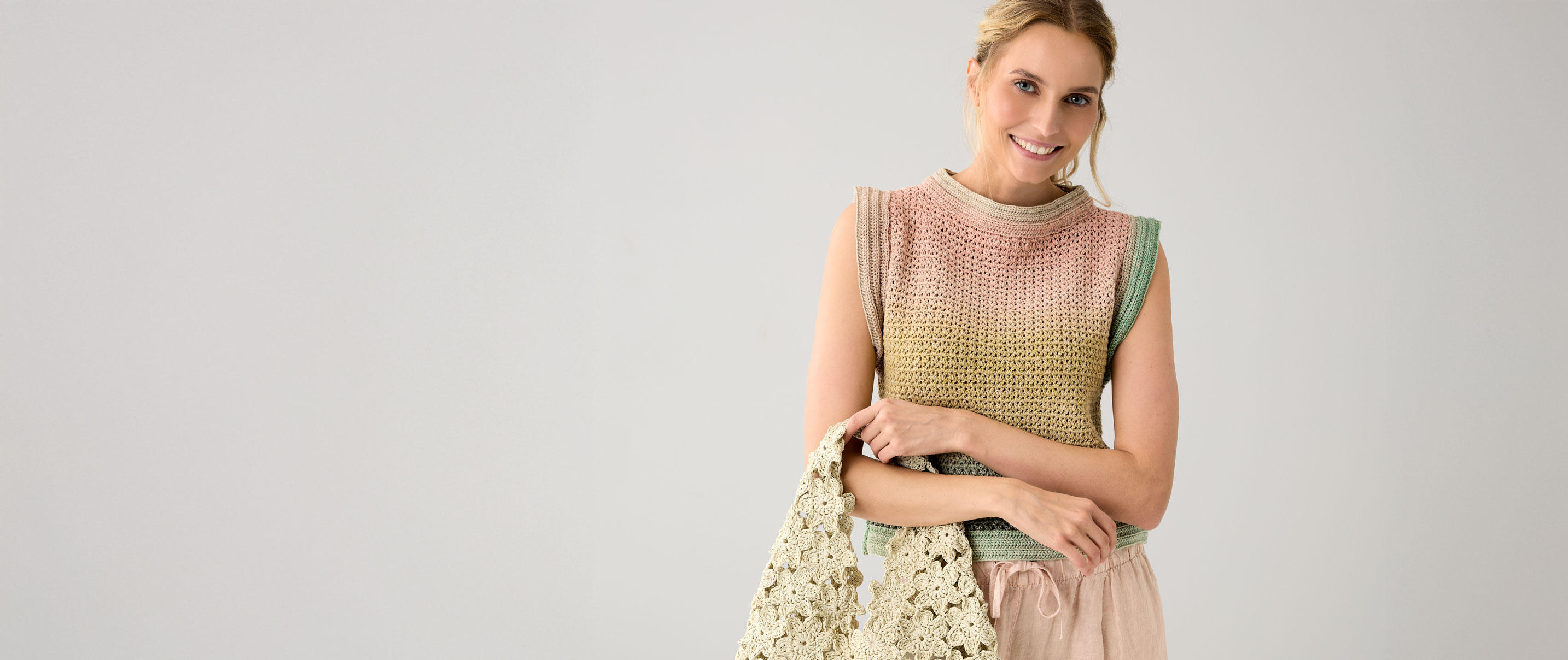 Frau trägt buntes Häkeltop und Tasche