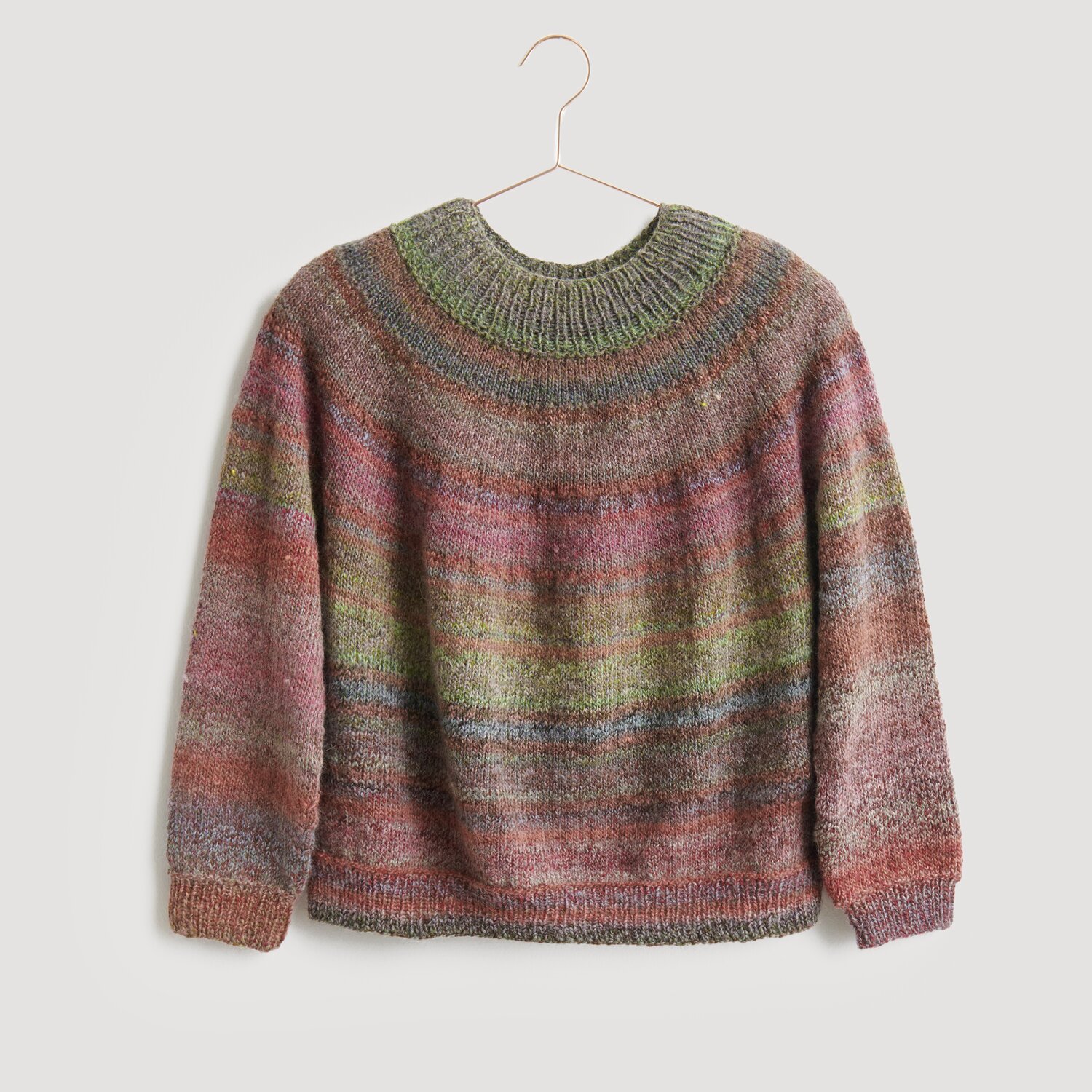 Pullover in sanften, mehrfarbigen Tönen, präsentiert auf einem Kleiderbügel. Der Strickpullover von Modell Legeware besticht durch sein einzigartiges Design und die harmonische Farbgebung. Ideal für kühle Tage.