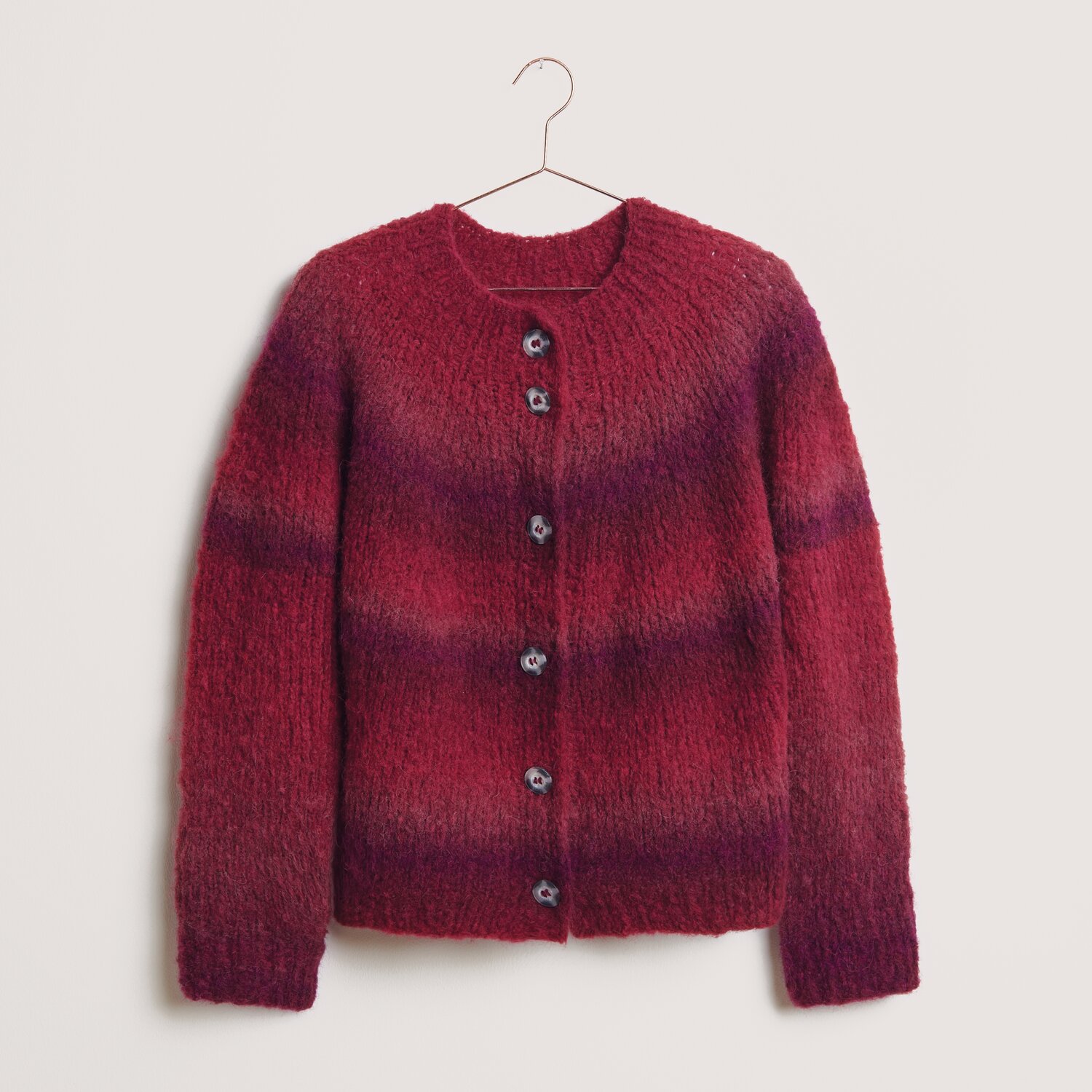 Fashion Alpaca Superfine Heavens Big Cloud 100g 280m Farbe Red Berries von Rico Design Fashion Alpaca Superfine Heavens Big Cloud: Roter Strickpullover mit Knöpfen, aus weicher Wolle, hängend an einem Kleiderbügel.