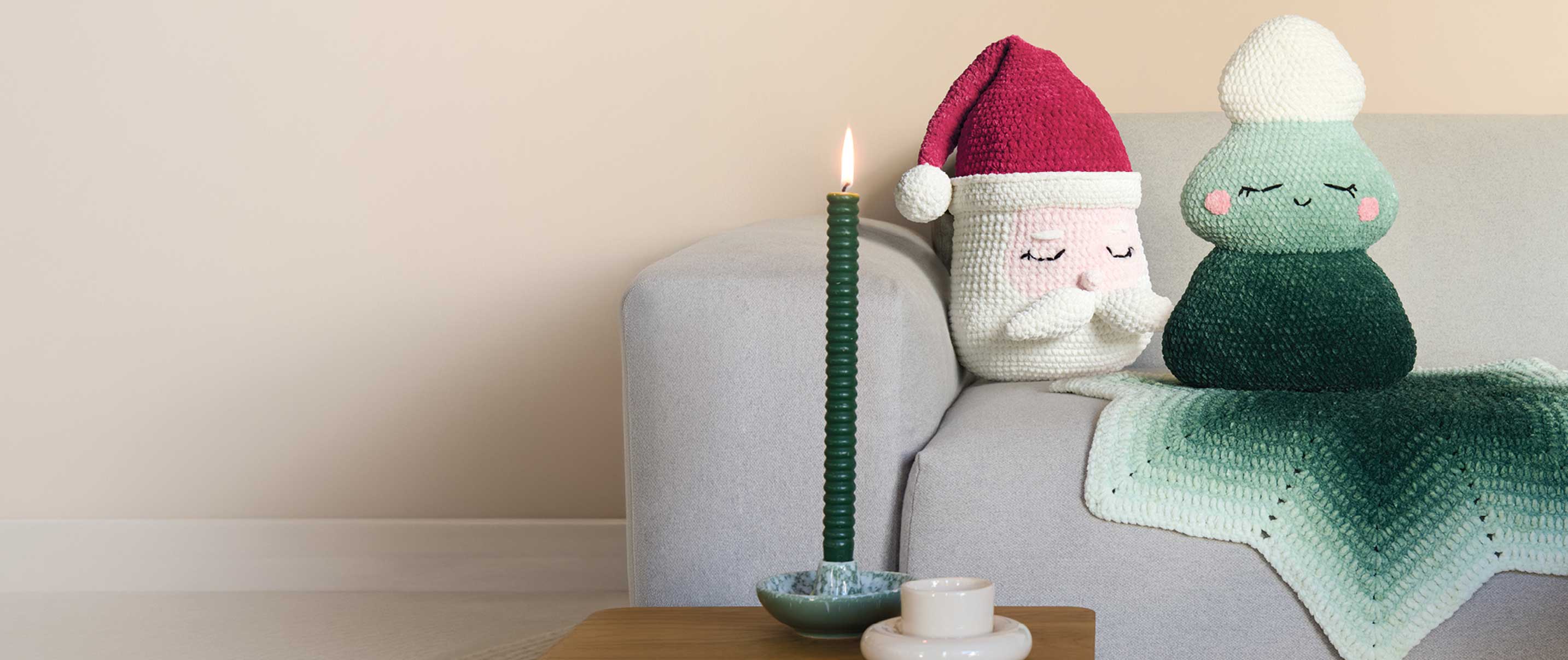 Gehäkelter Weihnachtsmann und gehäkelter Tannenbaum auf Sofa