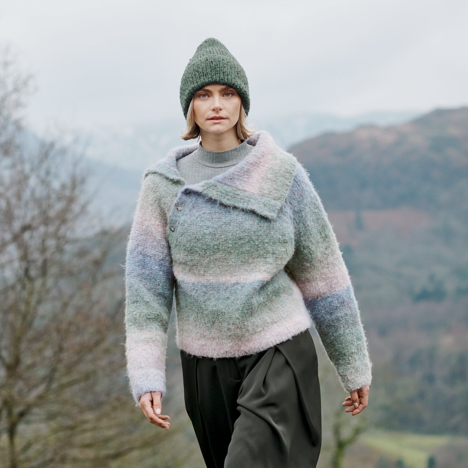Strickset Pullover Modell 10 aus Lovewool No. 23, locker geschnittener, flauschiger Streifenpulli mit asymmetrischer Knopfleiste, getragen von Frau in Berglandschaft