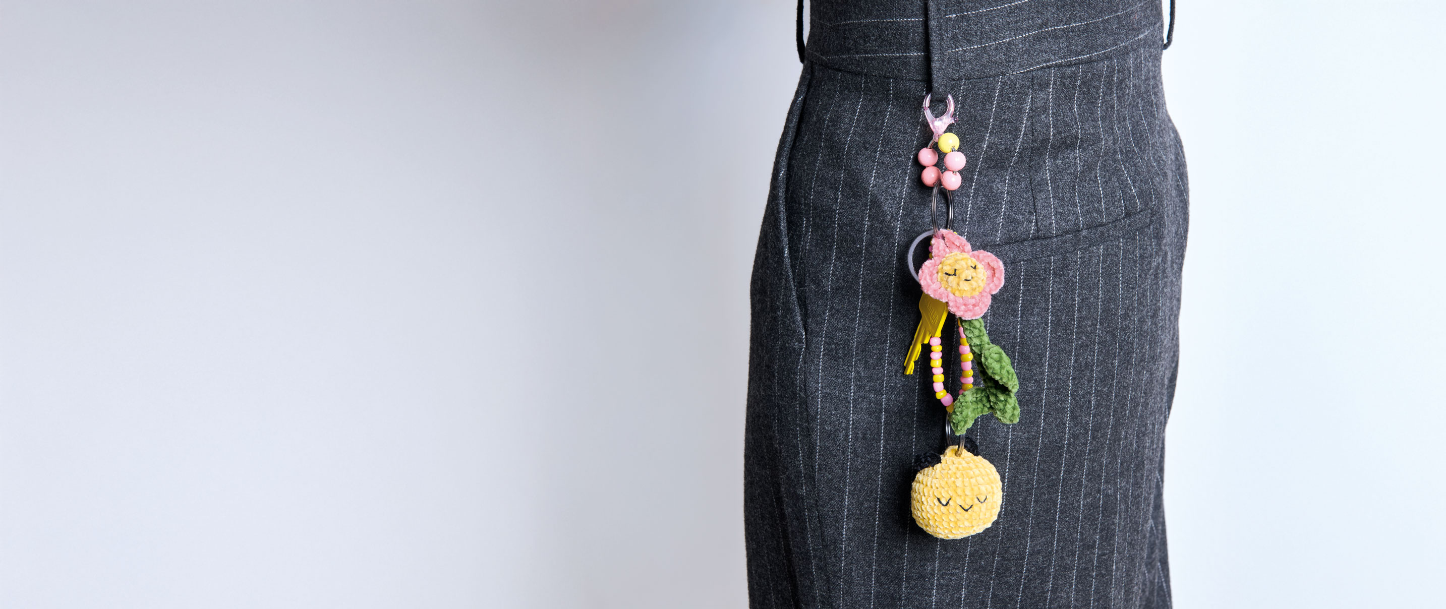 Schlüsselanhänger aus bunten Ricorumi Figuren hängt an einer Gürtelschlaufe.