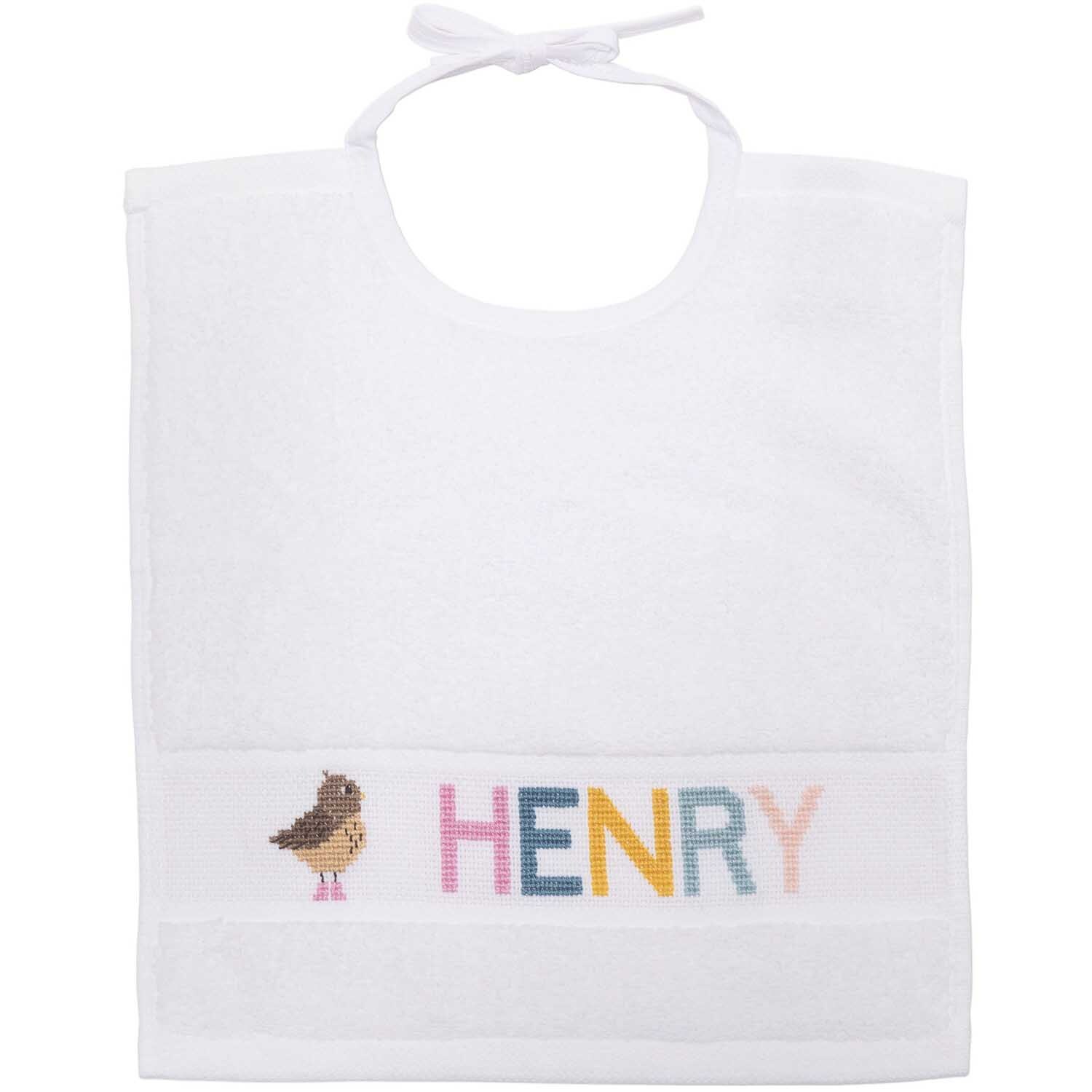Lätzchen 30x34cm von Rico Design mit Vogelmotiv und buntem Schriftzug "HENRY" auf weißem Stoff.
