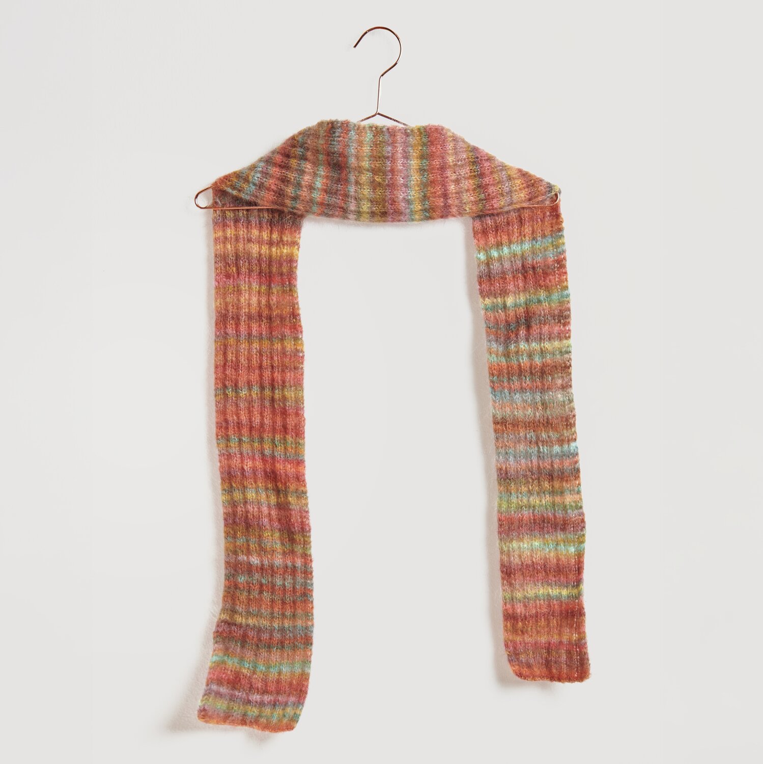 Strickset Schal Modell 10 aus Die Neue Masche No. 13 in bunten Herbsttönen auf einem Kleiderbügel. Fashion Meri Mohair Print verleiht weiche Textur.