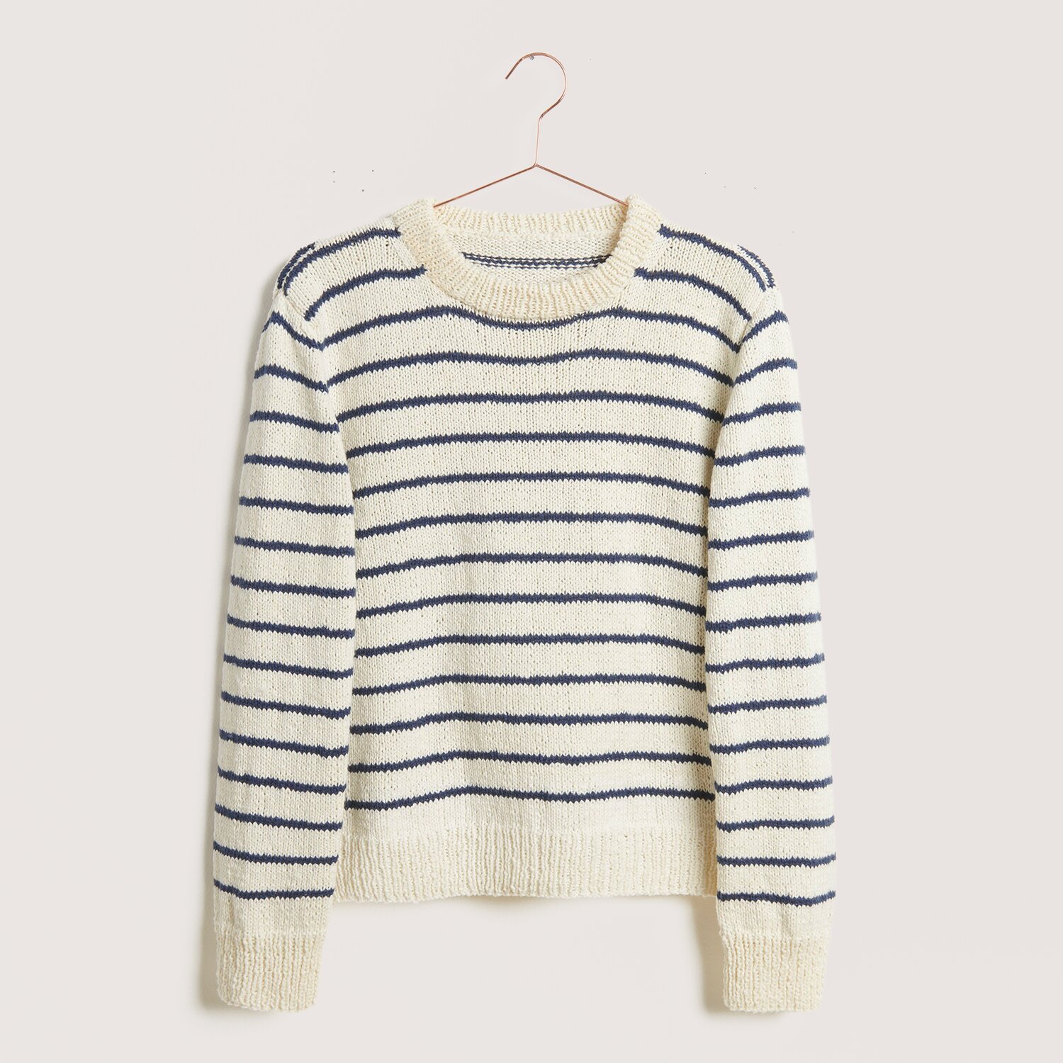 Strickset Pullover Modell 17 aus Die Neue Masche Nr. 9, gestreift in Creme und Blau, hängt an einem Kleiderbügel.