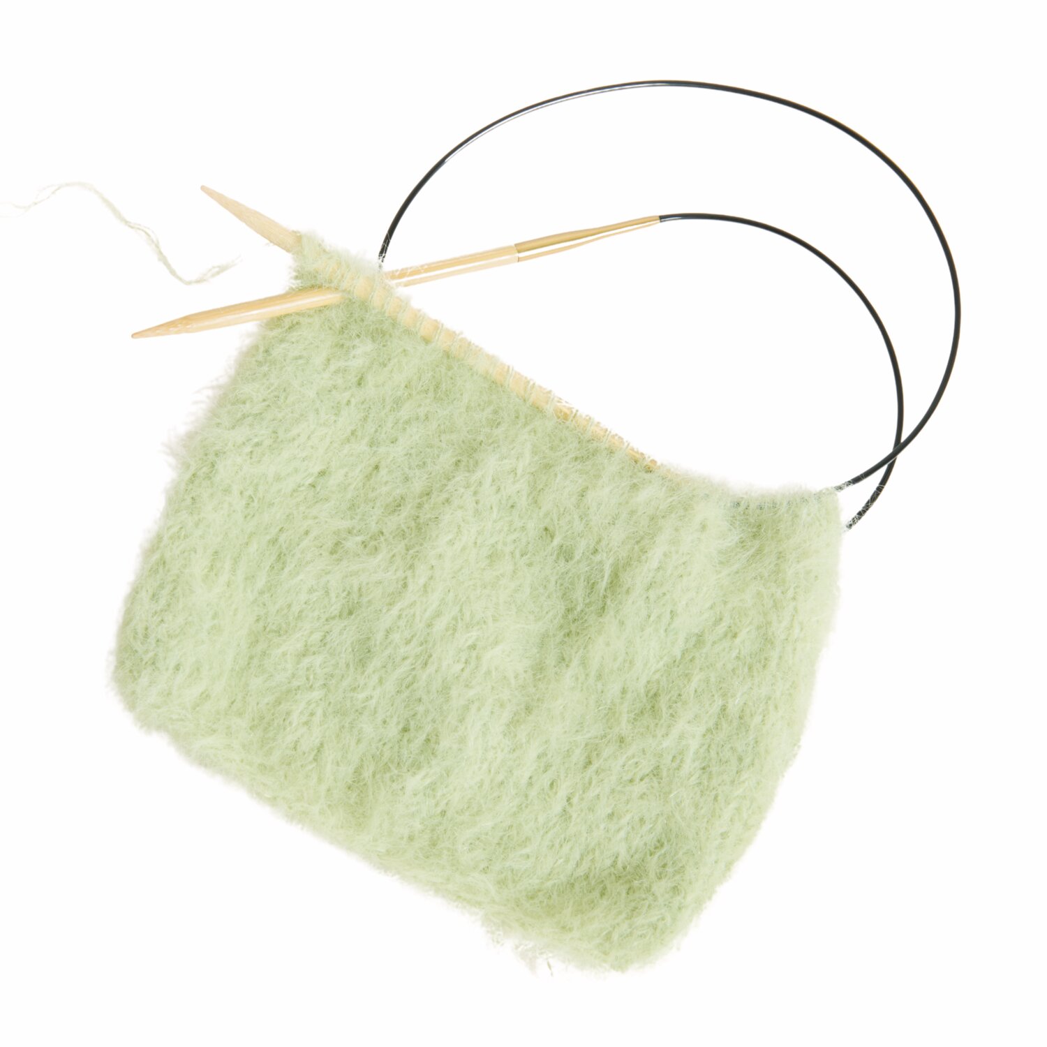 Made by Me No. 22 Frühjahr-Sommer: Strickprojekt mit flauschigem, hellgrünem Garn auf Rundstricknadeln.