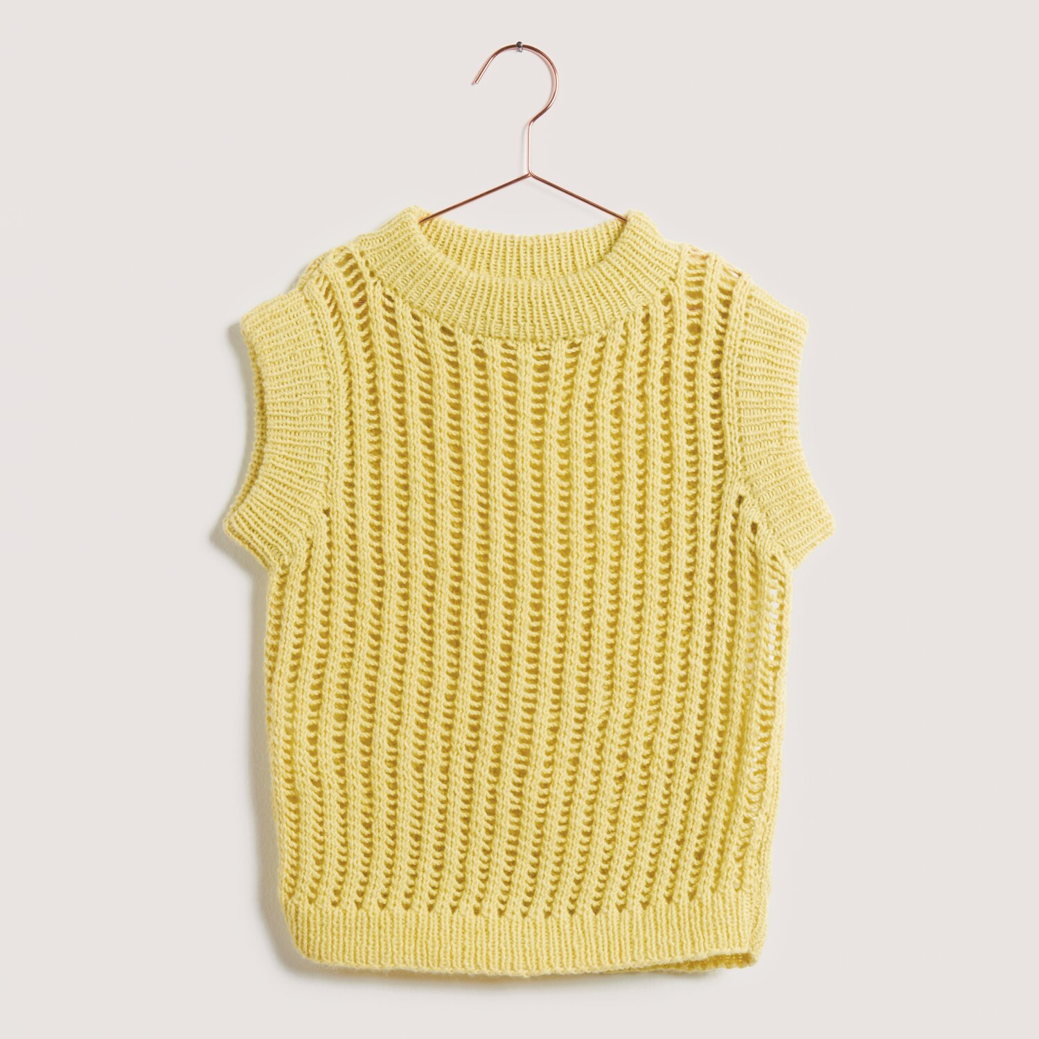 Made by Me No. 22 Frühjahr-Sommer: Gelber ärmelloser Strickpullover aus Creative Cotton Fleece dk, aufgehängt an einem Kleiderbügel.