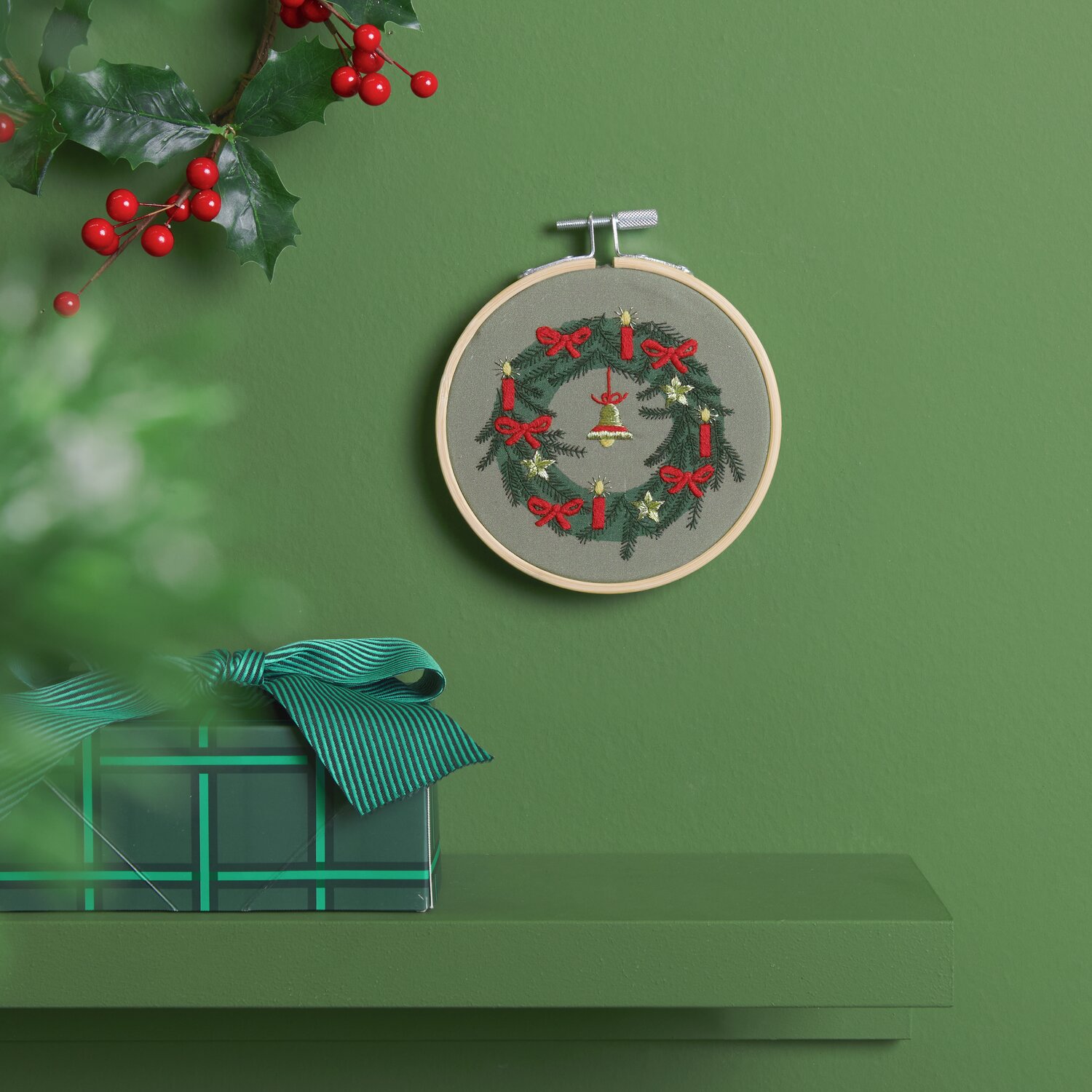 Stickpackung Weihnachtskranz vorgezeichnet von Rico Design, zeigt einen festlichen Kranz mit roten Schleifen und Kerzen auf grünem Hintergrund.