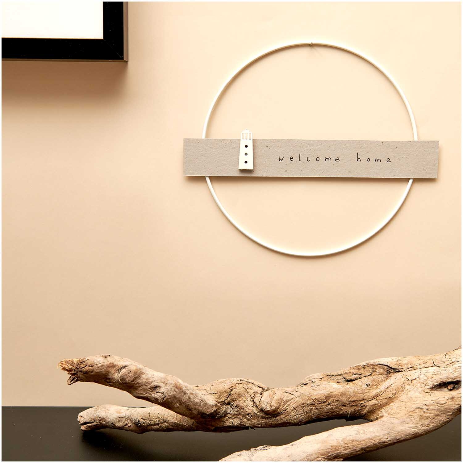 Metallring weiß glänzend von Rico Design an einer Wand mit "welcome home"-Schild und Dekoholz.