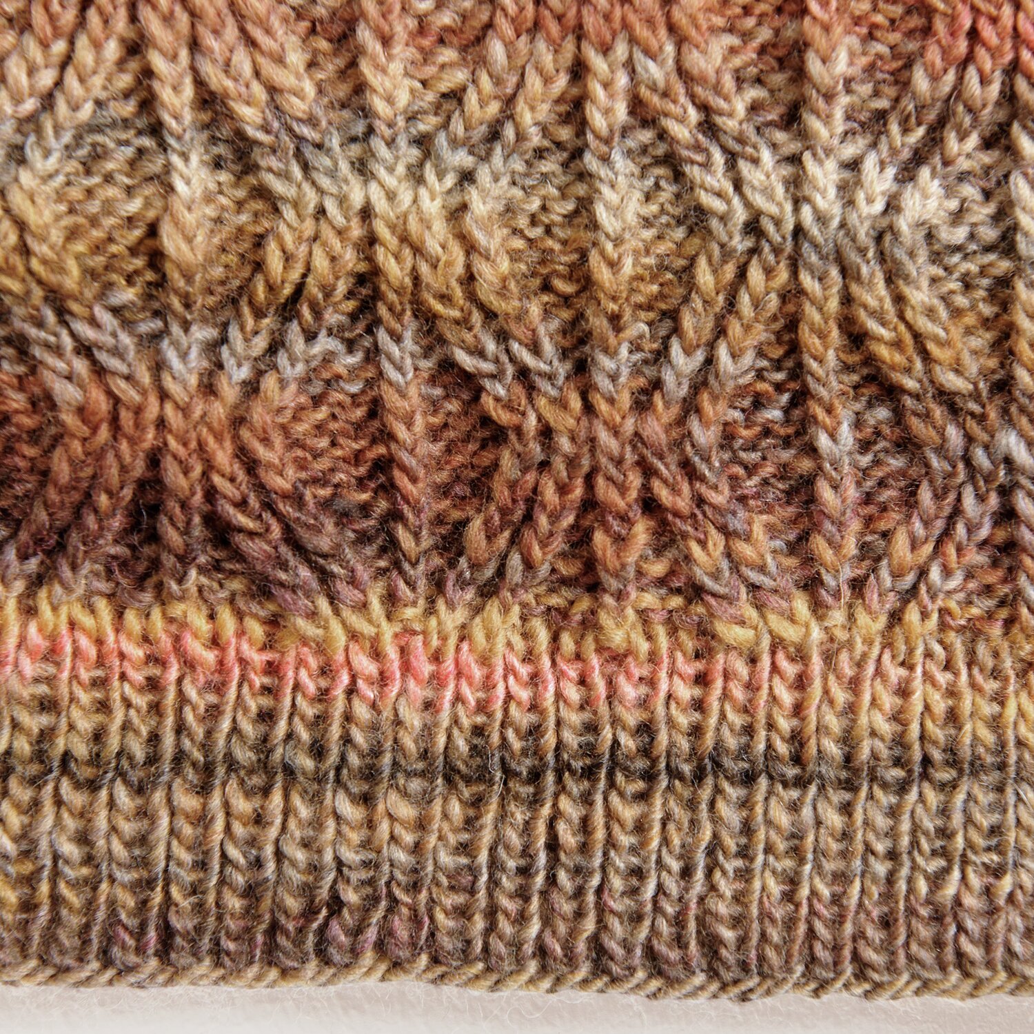 Creative Melange aran Wonderball zeigt ein gestricktes Muster in warmen Herbsttönen. Ideal für kreative Strickprojekte.