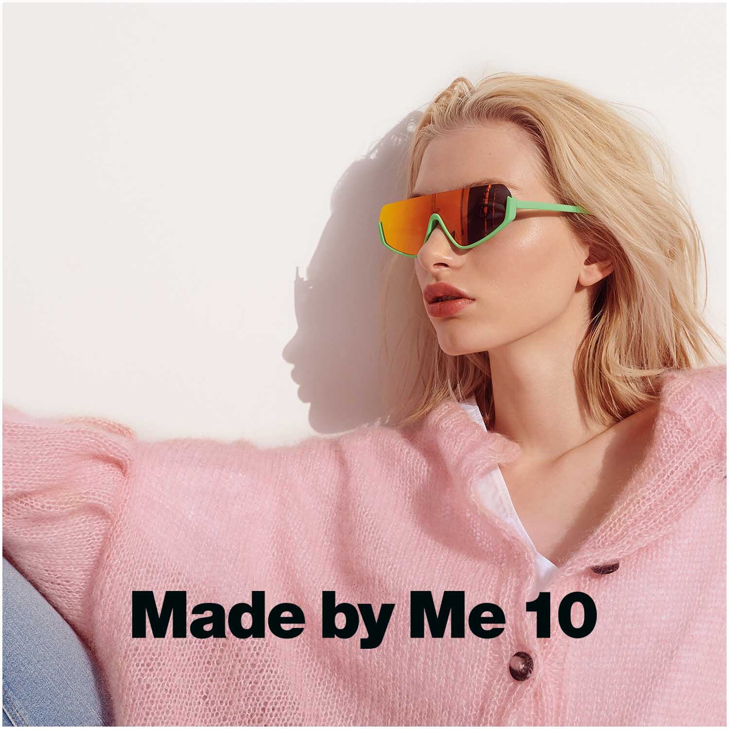 Essentials Super Kid Mohair Loves Silk: Frau in rosa Pullover mit Sonnenbrille, entspannt an eine Wand gelehnt. Ideal für stilvolle Strickmode.