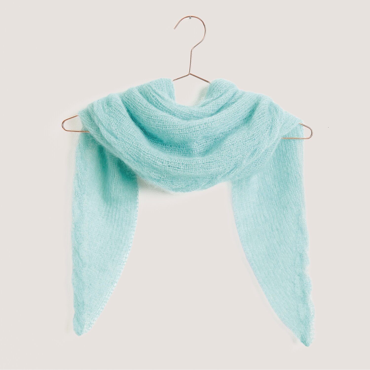 Strickset Dreieckstuch Modell 04 aus Tücher Special in Aquamarine, gefertigt aus weichem Mohair-Seide-Garn, elegant drapiert auf einem Kleiderbügel.
