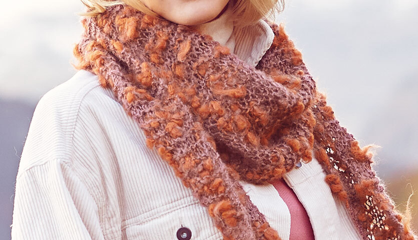 Strickanleitung Dreieckstuch aus Fashion Alpaca Vibes: Frau trägt ein warmes, flauschiges Dreieckstuch in Erdtönen über einer weißen Jacke.