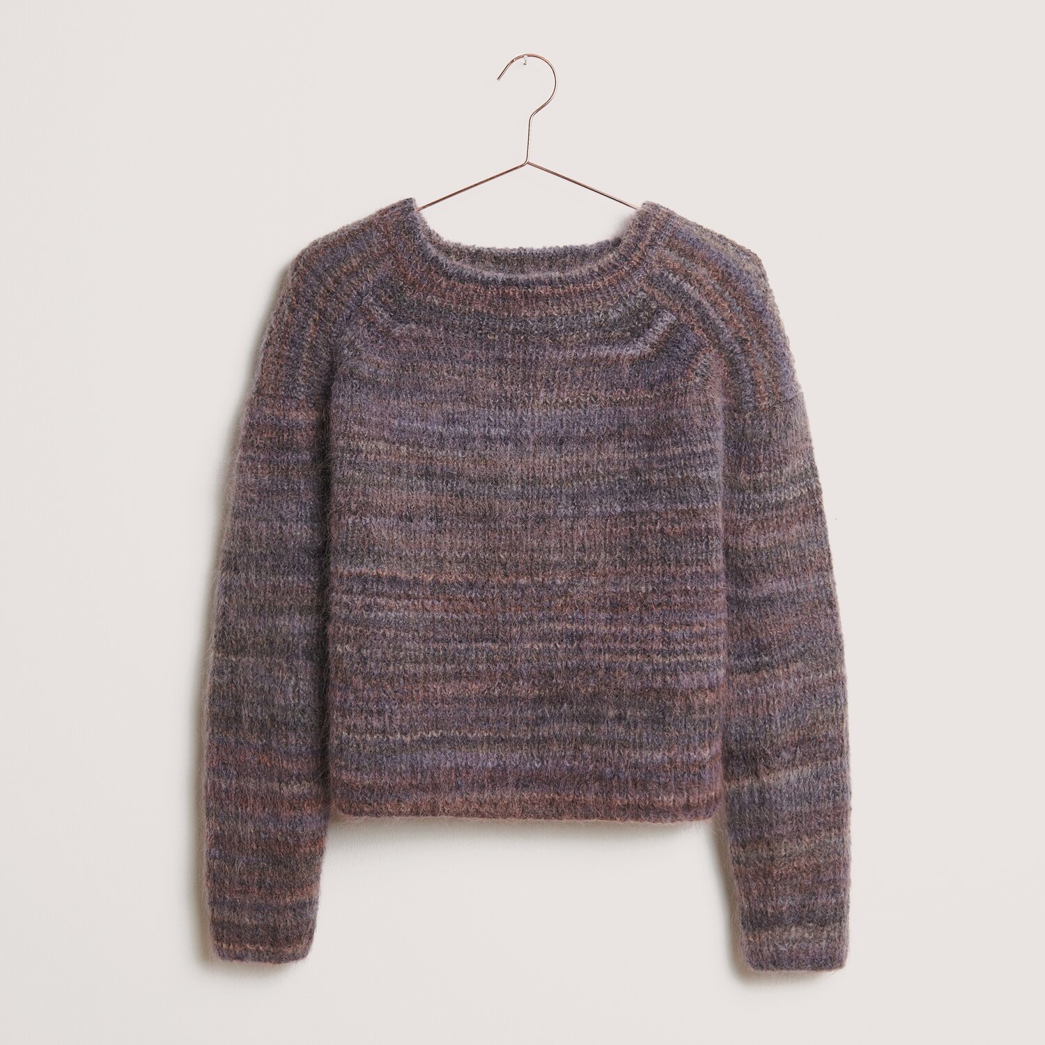Fashion Meri Mohair Print 50g 275m Farbe Smokey Purple von Rico Design Fashion Meri Mohair Print Pullover in Smokey Purple von Rico Design, gestrickt aus weichem Garn, hängt an einem Kleiderbügel.