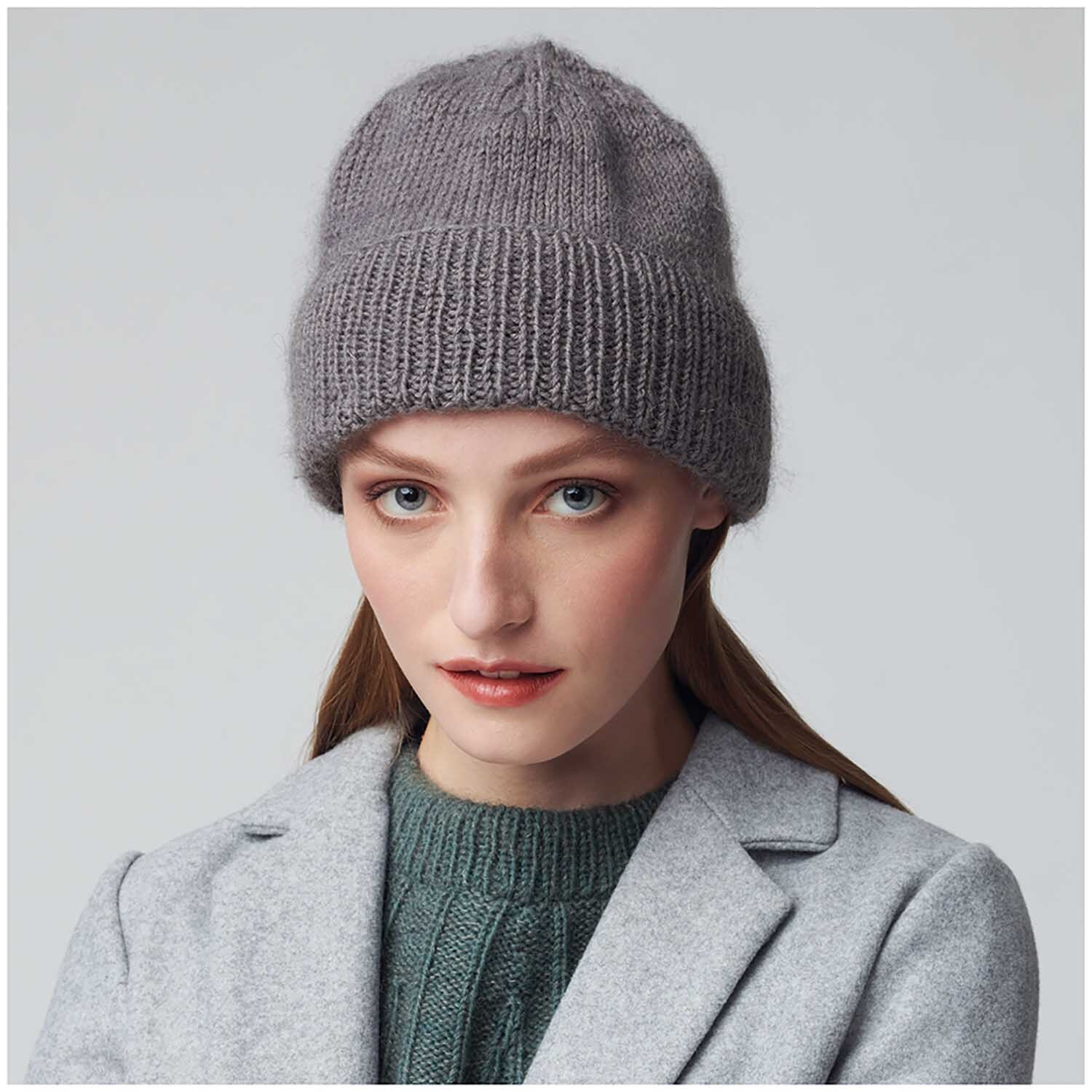 Essentials Merino dk: Frau trägt eine graue Strickmütze, passend zu einem grauen Mantel. Perfekt für kühle Tage.