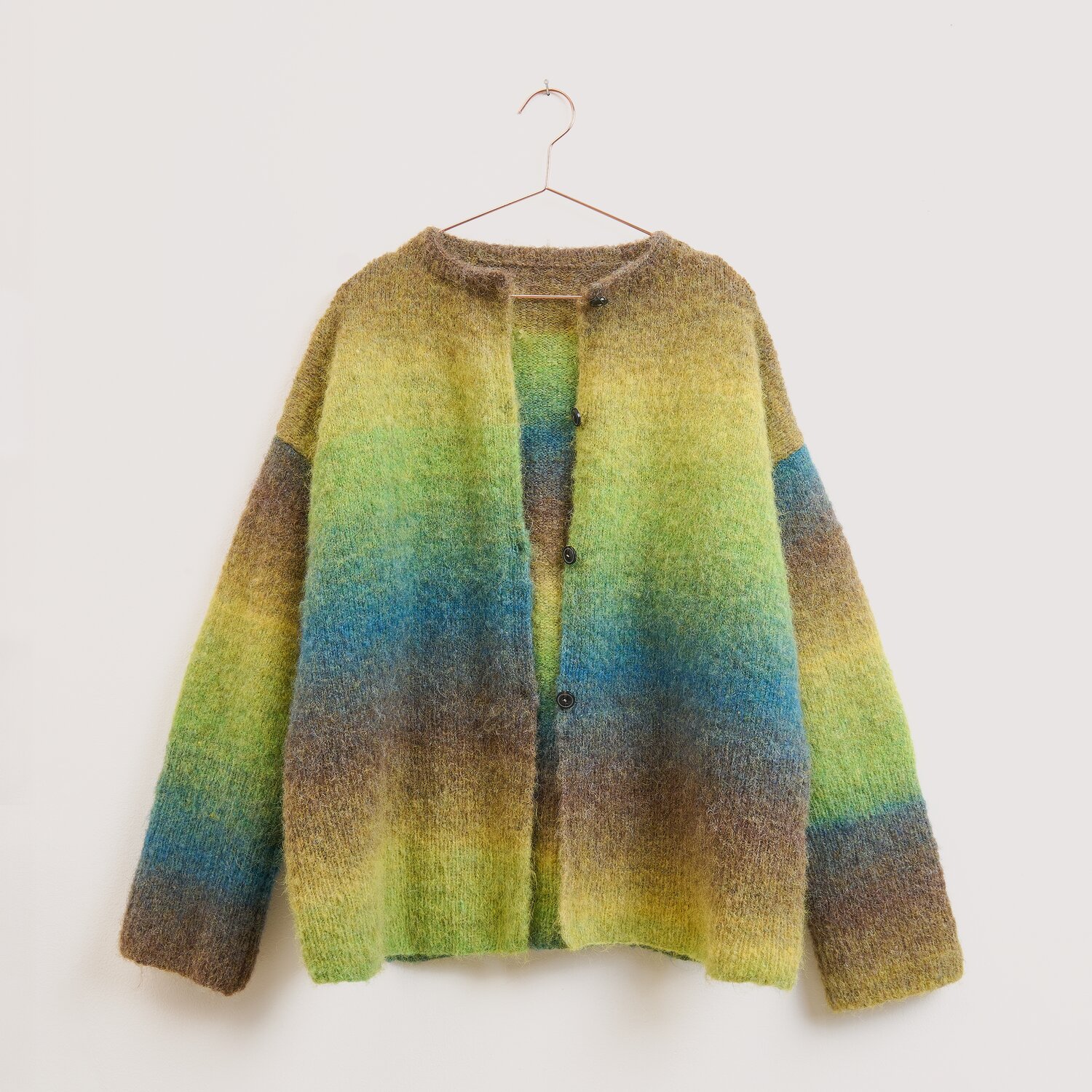 Strickset Jacke Modell 15 aus Die Neue Masche No. 16 Die Neue Masche No. 16 Herbst von Wolle Rödel, lockere Strickjacke mit breiten Farbverläufen in Braun, Grün, Blau und Gelb, hängend auf schlichtem Kleiderbügel