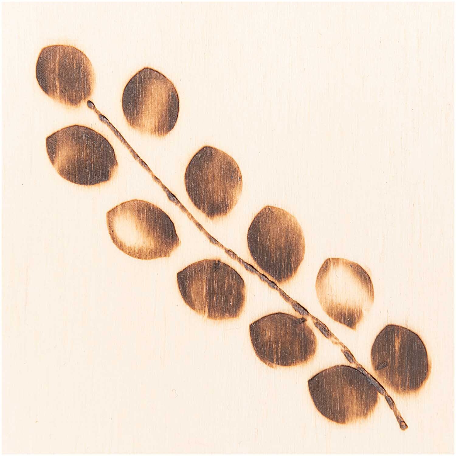 Brandmalkolben-Set inkl. 5 Aufsätze: Ein gebranntes Blattmuster auf Holz, ideal für kreative Projekte.