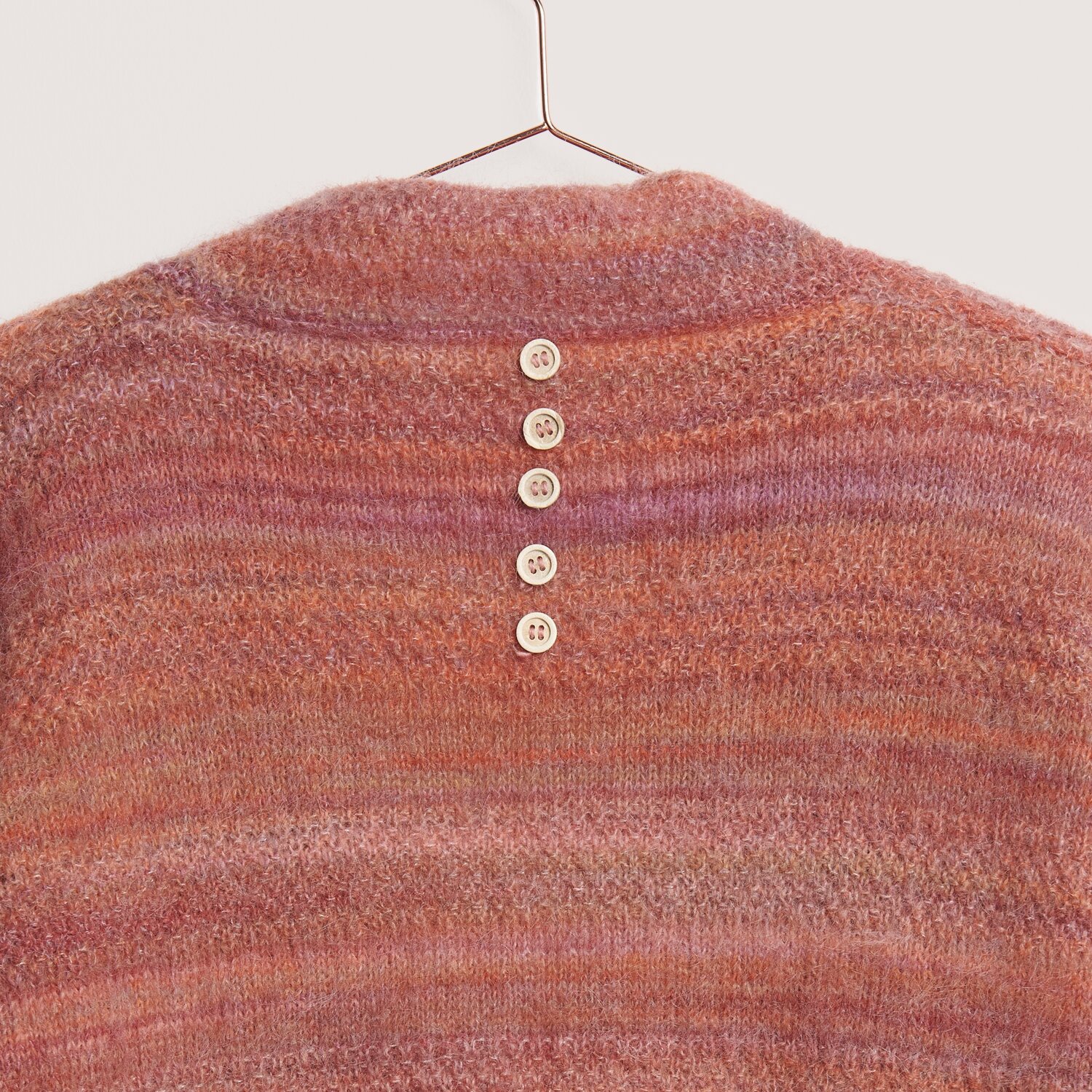 Fashion Meri Mohair Print 50g 275m Farbe Happy Sunrise von Rico Design Fashion Meri Mohair Print: Strickoberteil in warmen Tönen mit fünf Knöpfen auf der Rückseite.