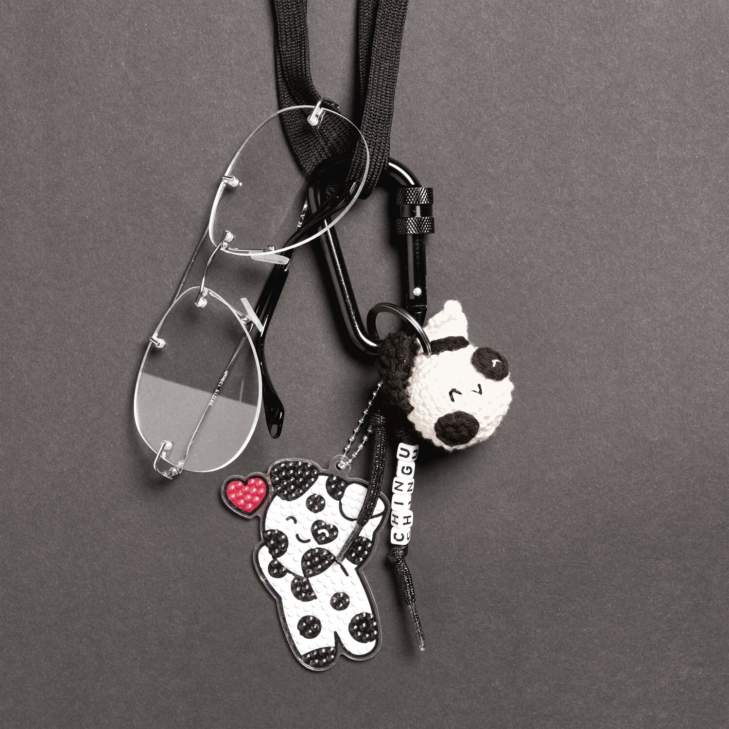 Ricorumi Rico Chingus Schlüsselanhänger mit Panda-Design, schwarz-weiß, an Karabiner mit Kette und Brille befestigt.