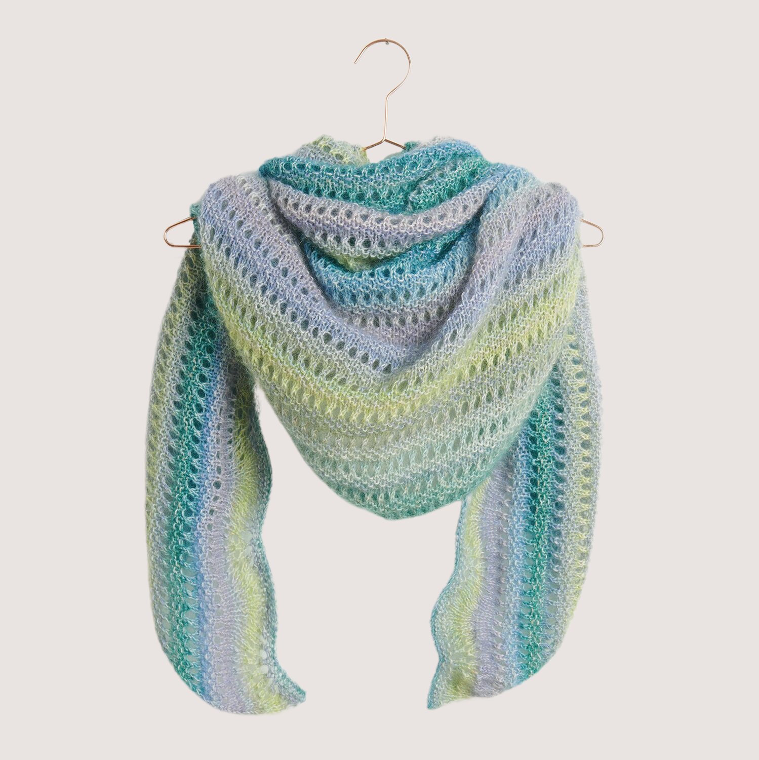 Strickset Dreieckstuch Modell 06 in sanften Pastelltönen, doppelfädig gestrickt, präsentiert auf einem Kleiderbügel.